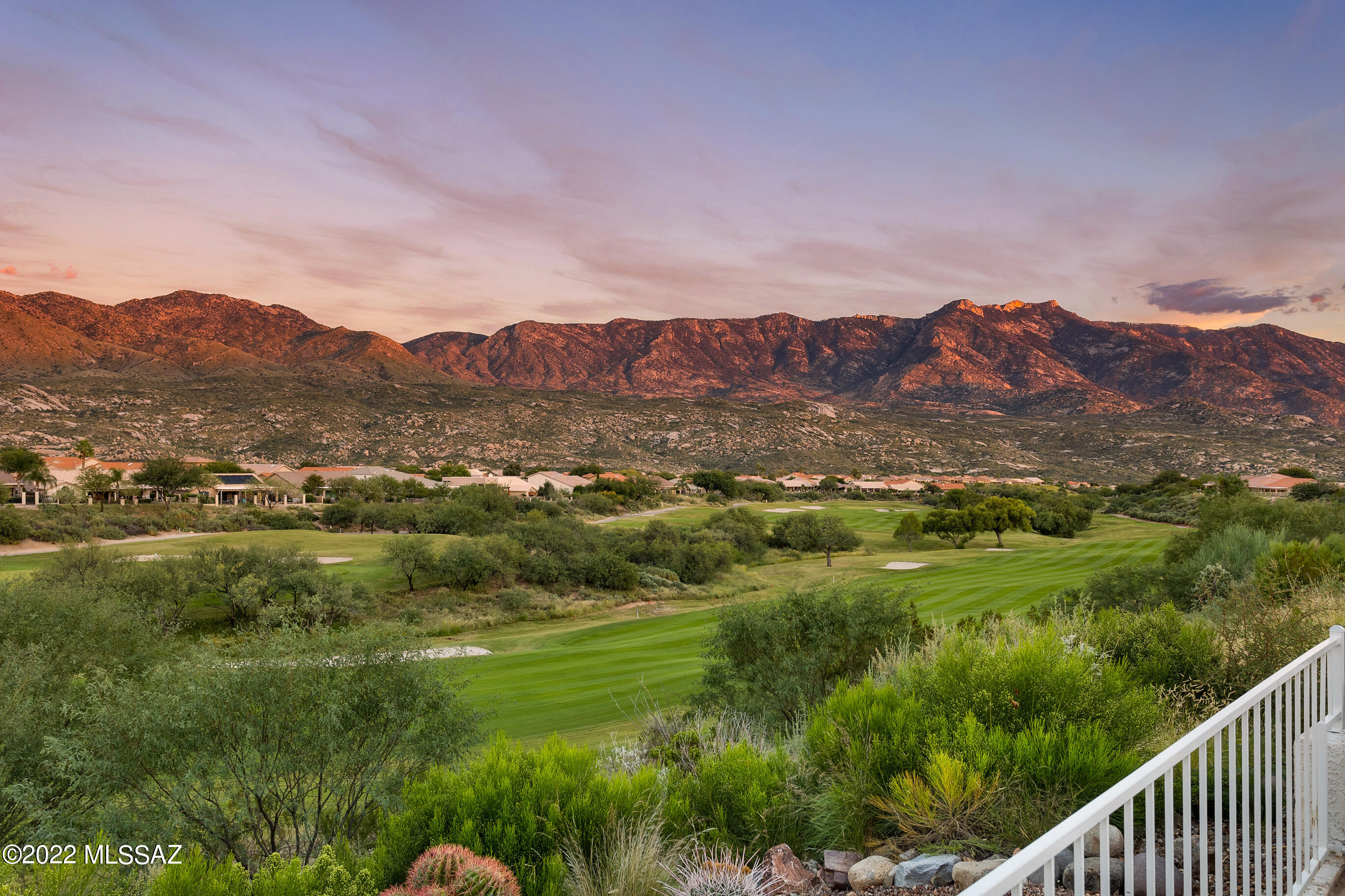 Perched on one of SaddleBrooke's most coveted ridgetop lots, this rare vantage point delivers panoramic mountain views and double fairway vistas that shift with every hour--mornings layered in soft peaks, evenings dissolving into colors that never quite repeat. The 3BR/2.5BA Galleria behind the view matches it all, with a rare balance of productivity, comfort, and entertainment. Vaulted ceilings and arched passageways set an architectural tone at entry--generous, light-filled spaces flowing into an open-concept kitchen and great room anchored by a stacked stone fireplace, mountain views, and a center island.  Outside, a widened and deepened patio dissolves the boundary between interior and exterior living. Multiple gathering spaces are anchored by a natural rock waterfall that cascades beneath a firepit patio into a peaceful pond below. For true cinematic escapes, the fully soundproofed private private screening room delivers: raised 120'' projection screen, immersive surround sound, and included AV equipment. Standout home office features custom built-ins, dual workspaces, and a Murphy bed. A tucked-away banco alcove with built-in fireplace sets the stage for intimate evenings under the desert sky. The owner's suite offers dual walk-in closets, quartz-topped dual vanity, and a spa-quality curbless shower. Thoughtful storage throughout, including extended garage w/built-in cabinetry and pull-down access to a full attic with reinforced flooring above the garage. Major systems are in order -- approximately 70% of the roof was replaced in 2022, with a newer HVAC system and water heater, offering buyer confidence from day one. SaddleBrooke is more than an address -- it's a community built around living well. World-class golf, tennis, pickleball, resort amenities, and a spirited social scene are right outside your door, while the Sonoran Desert reminds you daily that you chose somewhere truly special.
