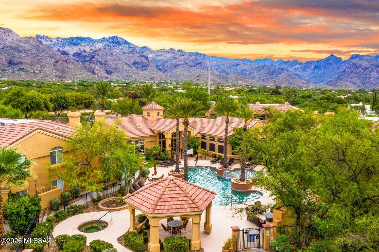 Affordable move in ready 1,048 SqFt, all electric energy efficient 2 bedroom/2 full bathroom end unit contemporary condo with breathtaking mountain views located in desirable gated Pinnacle Canyon community! Monthly $295 HOA dues include: refreshing community pool (heated in winter months), spa, exercise facilities, massive club room, gated community, garbage collection, wireless internet, pest control, roof repair, outside building & common area maintenance, covered parking, lush green grass manicured lawns and BBQ areas. Inside buyers will appreciate energy efficient double pane windows, luxury plank flooring, carpet in bedrooms, spacious great room with mountain view, plantation shutters, amazing natural light, covered balcony access, storage, internal laundry room w/washer & dryer included, new ceiling fans, new water heater 2025, open concept kitchen with dining area, kitchen bar, ample counter space, modern Maple shaker kitchen cabinets, double sink, new garbage disposal 2026, crisp white appliance package with refrigerator, brand new oven 2026, new dishwasher 2026 and new built-in microwave 2026. Spacious primary bedroom suite with slider out to covered patio, walk in closet storage, large full bathroom with executed height modern vanity and tiled shower/tub. Enjoy the peace of mind of 2-10 Home Warranty coverage which can transfer to new owners. Rentals are allowed, please check with the HOA for their terms.

Located in famed Catalina Foothills school district, minutes to Sabino National Park, walking distance (across the street) to restaurants, groceries and shopping. This will make a fantastic second home for seasonal visitors or anyone looking for low maintenance living. Call to make your appointment to view this turnkey condo today!!!