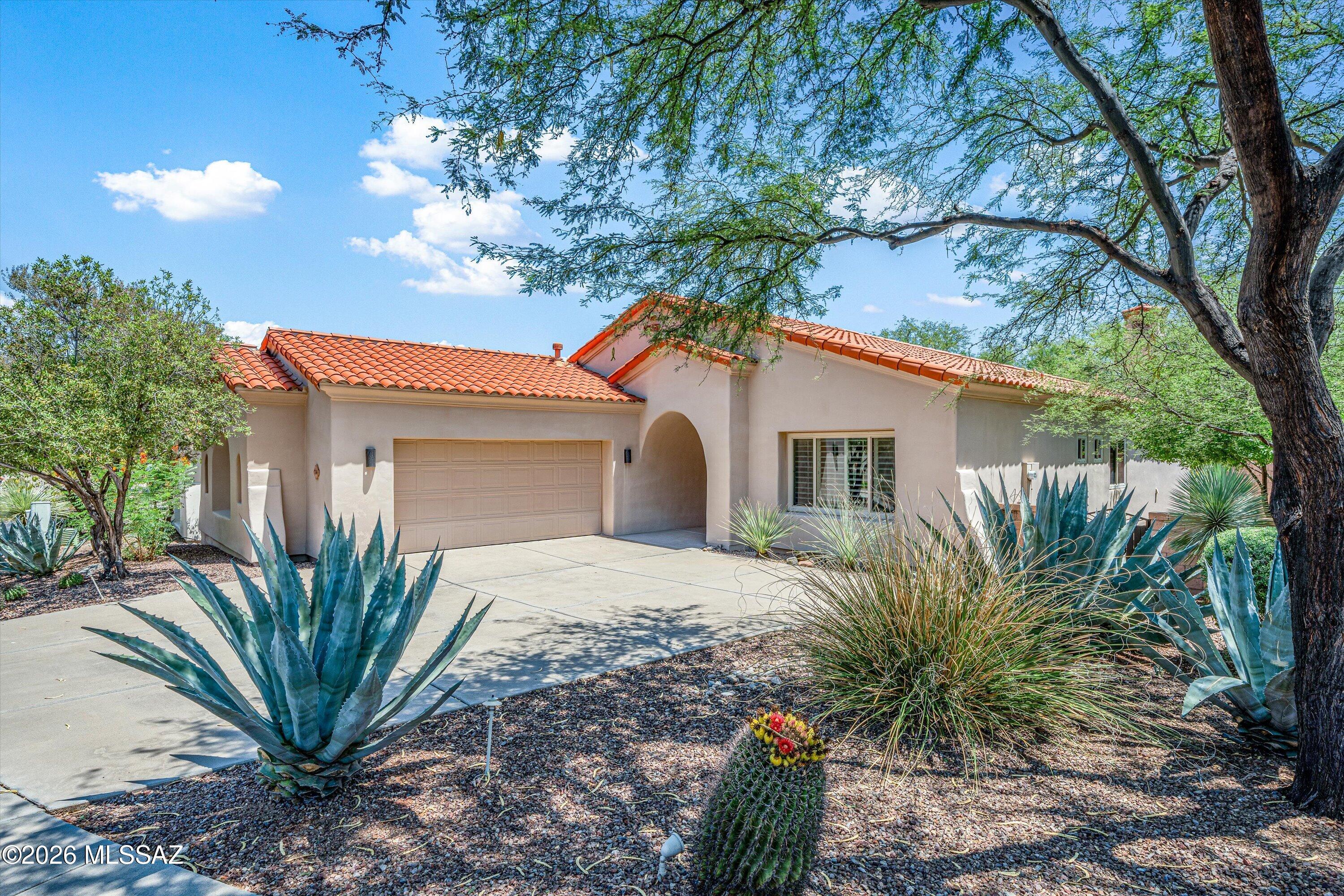 Soft contemporary on one of Vactor Ranch's best homesites, backs to lush  common area in this gated community. New polished concrete flooring run throughout the home and onto both the front and back patios. The great room anchors the layout with a gas fireplace and walls of windows, opening to a Tuscan style kitchen with a tons of storage, a granite island, a gas cooktop with charming tile backsplash, walk-in pantry, and a new Bosch refrigerator. 3BR/2BA both updated with new toilets and lighting. Primary suite has a walk-in closet, soaking tub, separate shower, and private patio access. Two-car garage now finished with epoxy flooring. Sewer line replaced (12/23). Backyard has artificial turf, covered patio, and easy care desert planting. Plantation shutters throughout.