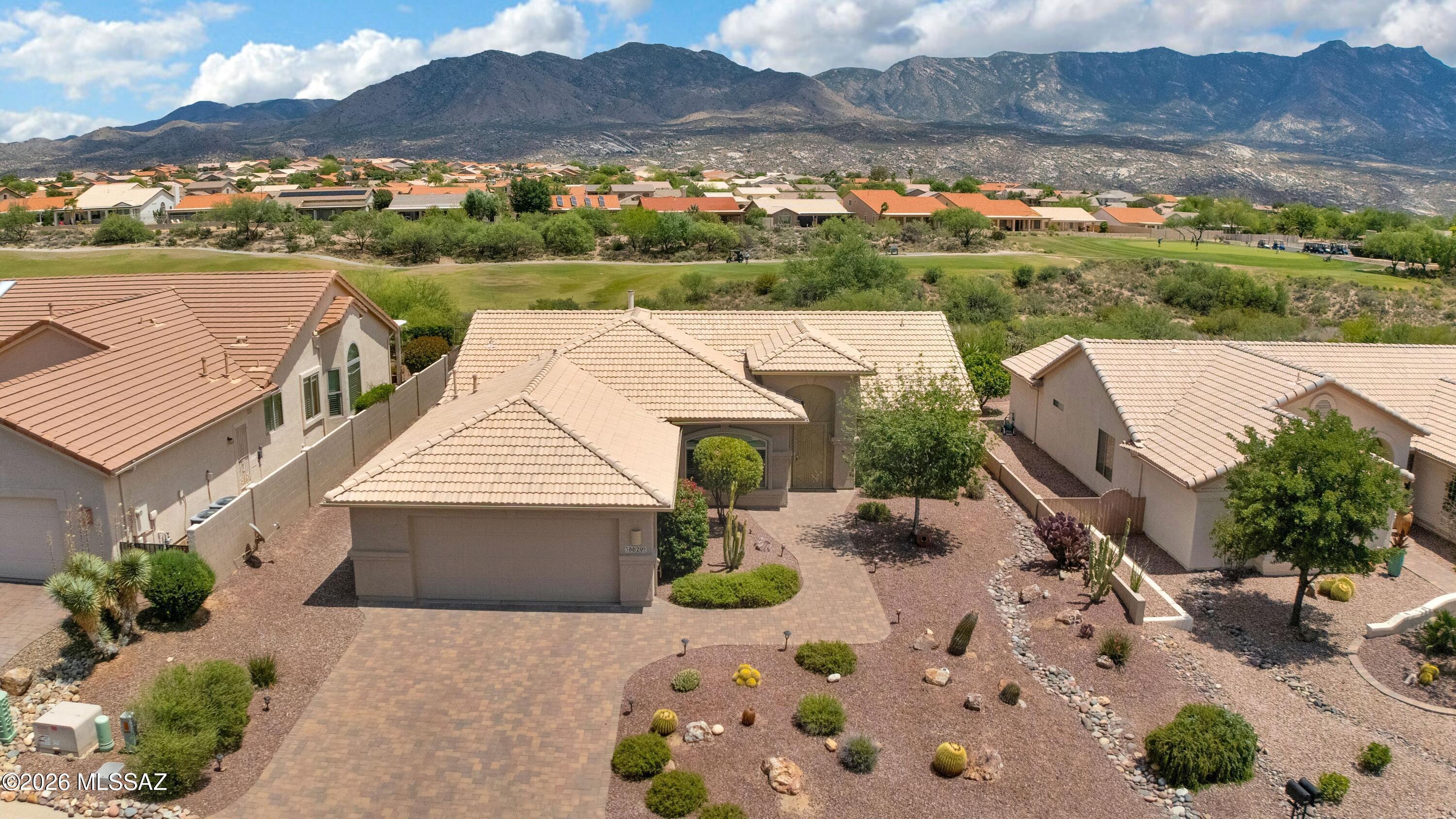 Golf course views and mountains - this Laredo delivers! This 2BD/2BA home features ceramic tile floors throughout and a beautifully updated primary suite with wood flooring, bay window, ceiling fan, and walk-in shower. The kitchen features granite countertops, stainless steel appliances, gas range, pullout shelving. Ceiling fans are found throughout the home for added comfort. Step outside to the patio with gas hookup for your grill and take in the sweeping golf course and mountain views and watch wildlife from your backdoor. Additional highlights include gas fireplace, paver driveway & patio, 2015 HVAC system, 2014 water heater, mudroom with sink and storage, and an extended 8' garage, perfect for extra storage or workspace. Windows and patio door replaced 2017.