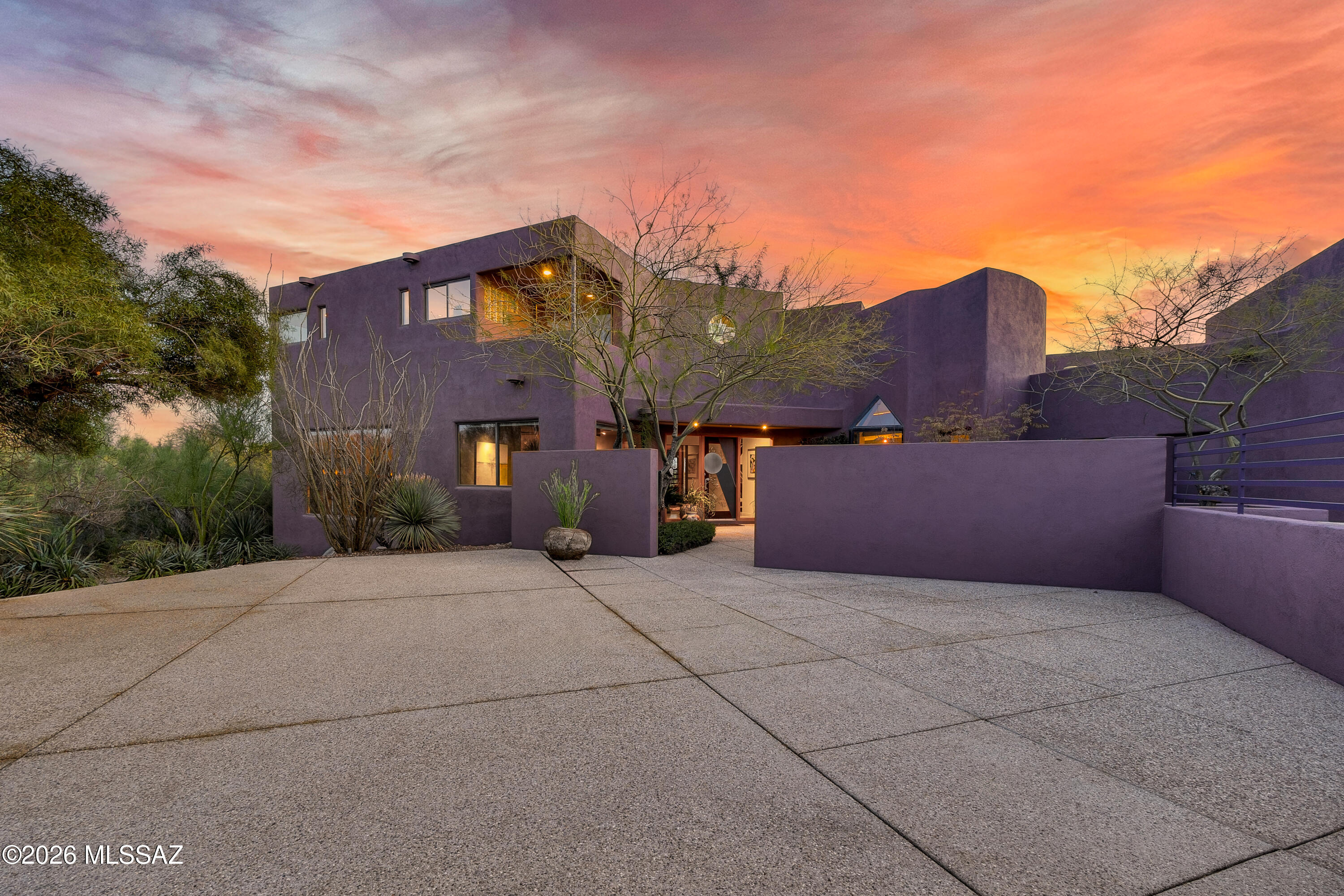 This architecturally bold 90's Desert Postmodern residence by John Campisano is anything but ordinary - soaring spaces, sculptural lines, and walls of glass that frame the desert like artwork. Warm, curated interiors by Lori Carroll soften the drama, creating rooms that feel both impressive and inviting - most curated furnishings available for a seamless move-in experience.
The sunken great room draws everyone in with custom cabinetry, a statement fireplace, and rich birdseye maple details. The chef's kitchen - equipped with Dacor dual ovens and a walk-in pantry - makes entertaining effortless.
Upstairs, your private retreat awaits: sitting area, fireplace, dual closets, fitness room, + balconies that open to panoramic mountain and city views. Step directly to the resort-style pool and terrace - perfect for sunset swims and unforgettable gatherings.

With a game room, screened outdoor kitchen, guest suite with steam shower, darkroom, and oversized 3-car garage, this is more than a home - it's a lifestyle elevated above the ordinary.

If you've been waiting for something distinctive, dramatic, and undeniably Tucson - this is it.