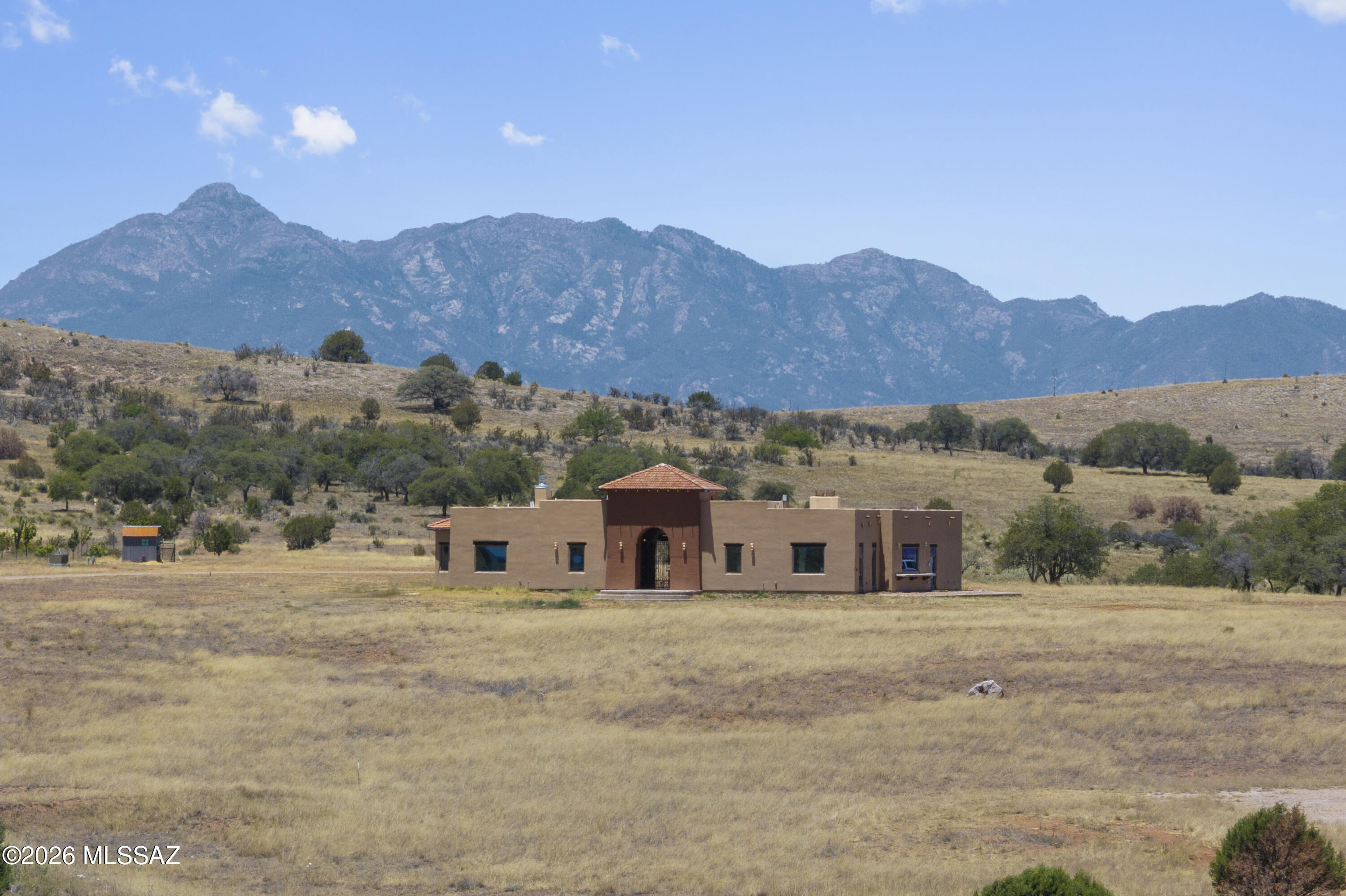 ABSOLUTELY INCREDIBLE LAND with direct access to Coronado National Forest with SPECTACULAR 360 views.  High end custom 2759 sf with beautiful wood beams & doors, lovely Mexican tile accents.  Gourmet kitchen w/2 refrigerators, 2 dishwashers, 2 microwaves, and soft-close cabinets. Large patio area for outdoor barbeques. Separate TV room with area for future wet bar.  Dramatic front entry foyer plumbed to add a fountain.  2400 sf metal garage/workshop/storage building. Basic horse facilities, w/crossed fenced pastures.  Huge orchard with a variety of fruit trees.  Separate RV pad, /Basketball court.  New red tile roof, flat roof just re-coated.  New solar electric gate, water heater & most of the exterior lighting fixtures. Neighboring rancher willing to offer grazing lease.