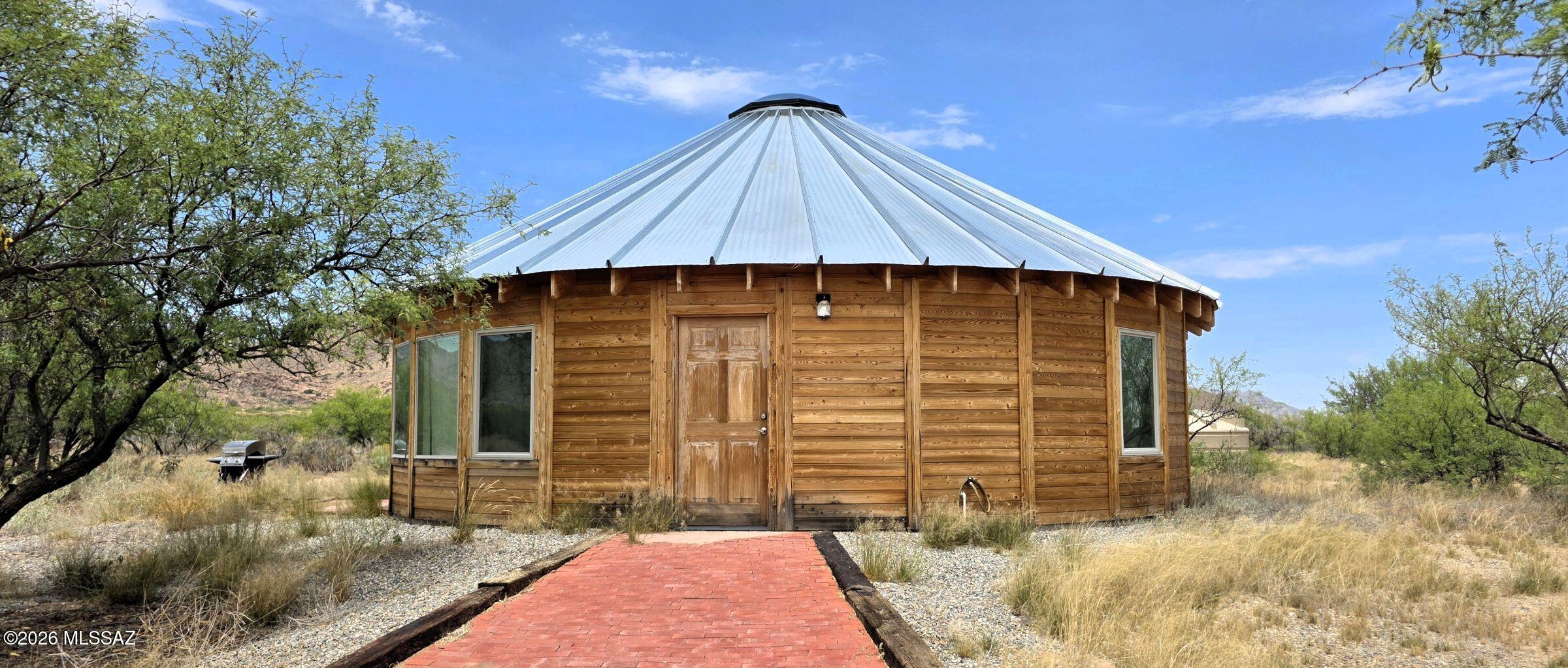 This is a truly unique property on 5 acres in Pearce, AZ. It's a Yurt, built in 2022 on-site with a permanent foundation. The building permit lists it as a single-family home, though county records don't reflect that. Sellers were seasonal, so it's like new!  Located at 636 W Pearce Rd, the tax information applies only to the land. Inside, you'd never guess it's a Yurt, with plenty of custom features. The exterior is all cedar, not the typical Yurt canvas siding. It's 900 square feet, 2 Beds, 1.5 baths, per the building plans. All furniture, household items, bedding, and linens are included, except for two Pendleton blankets. The property has a conventional septic system, a 5,000-gallon cistern, and the entire 5 acres are fenced with four-strand barbed wire. FULL RV hookup for your quests!