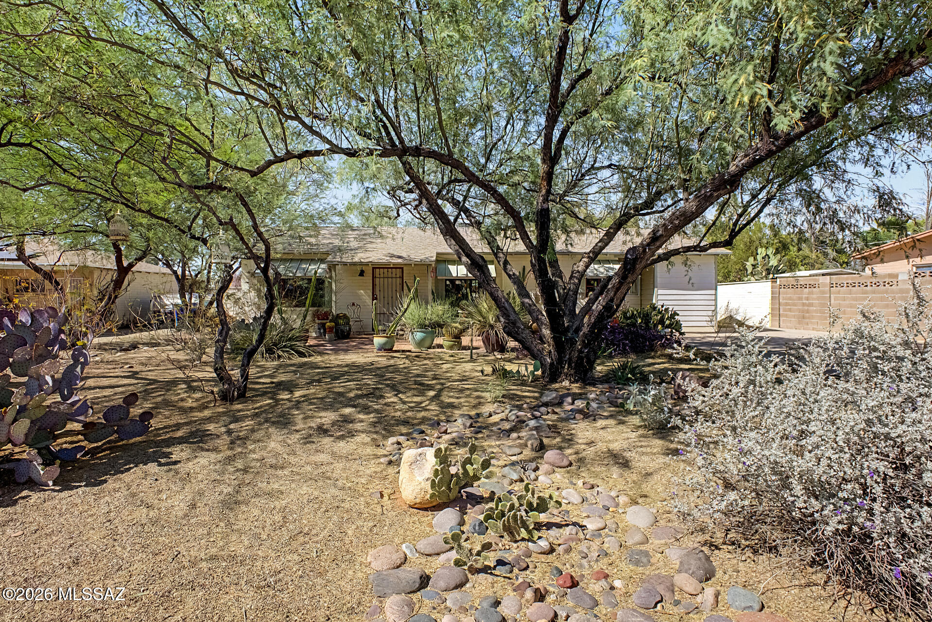 One-of-a-kind private oasis in the heart of Tucson with major updates already done. This 2 bedroom, 1 bath home features a new roof (2024) and an HVAC system less than 10 years old for peace of mind. Inside offers an open split floor plan with hardwood and tile flooring, an updated kitchen with hickory cabinets, Corian countertops, breakfast bar, dining area, and bonus space. Updated energy-efficient windows and doors plus remote rolling shutters add comfort and security. The primary bedroom includes a walk-in closet with storage loft. Enjoy approx 800 sq ft of covered outdoor living with a gas beehive fireplace, plus a lush backyard with mature desert plantings, shade, passive water system, and a storage shed with AC.