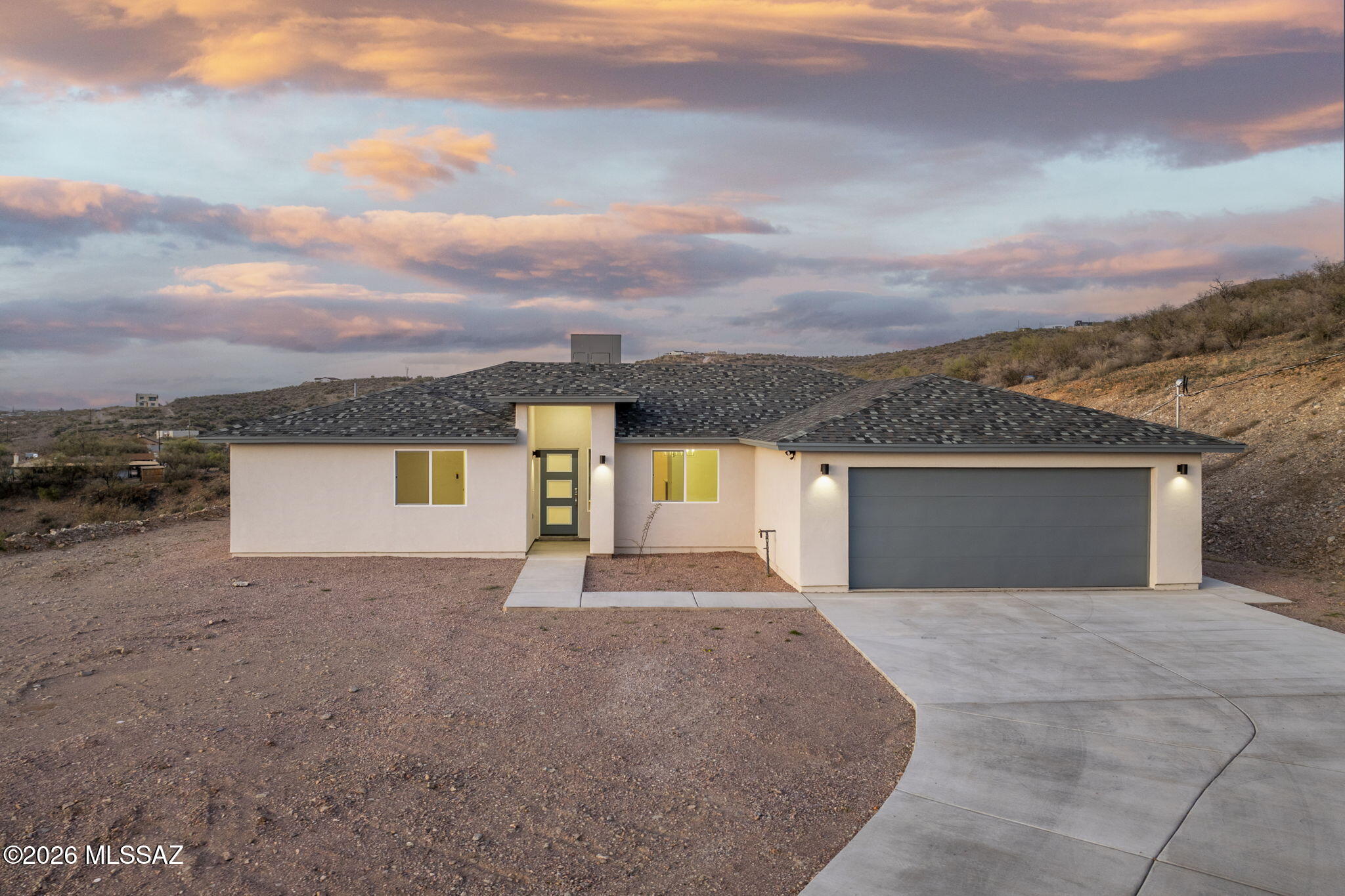 Brand-new home perched on a scenic hillside with breathtaking mountain and sunset views on 1.32 acres. This 3-bedroom, 2-bath home welcomes you with an open floor plan that feels bright, airy, and inviting. The kitchen features modern soft-close cabinetry and quality finishes carried throughout the home. Both bathrooms include dual sinks and beautifully tiled showers, with a convenient prep vanity in the primary suite. The extended insulated garage offers plenty of space and an exterior door for easy access. Step outside to the covered patio and take in the panoramic views, watch the sunset, and enjoy the peaceful desert setting. Located just minutes from I-19, providing quick access to shopping, dining, and nearby destinations.
