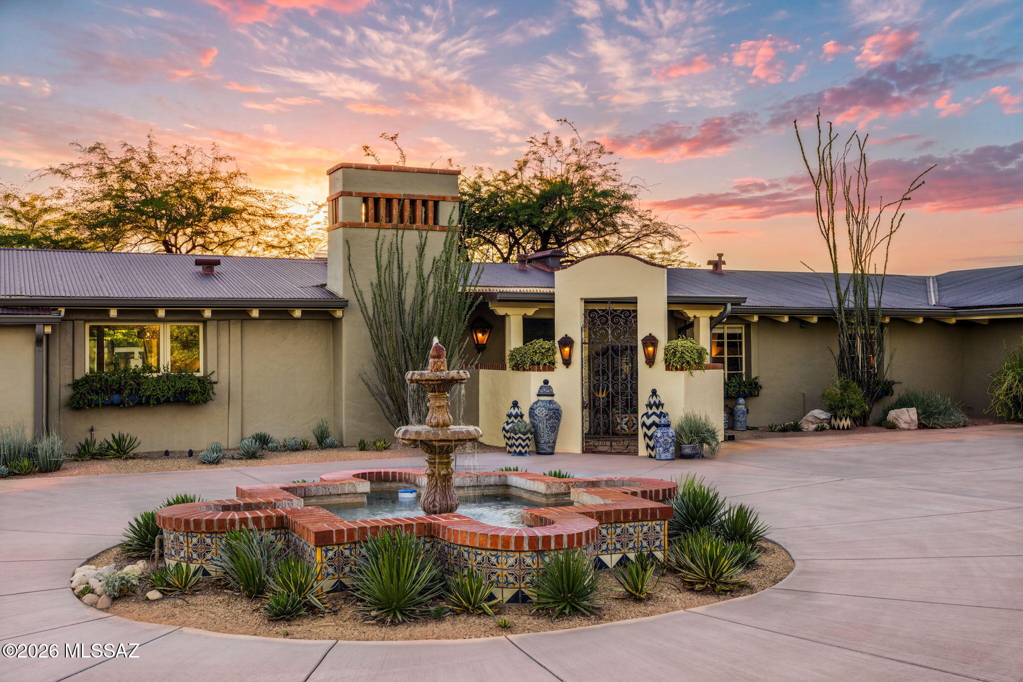 Tucked into the heart of historic Catalina Foothills Estates, this beautifully maintained and restored 1952 work of Josias Joesler offers a rare opportunity to experience one of the Southwest's most celebrated architects in a home that feels intimate, approachable and exceptionally livable. Set on approximately one elevated acre with shimmering city-light views, the home is rich with the details that make Joesler architecture so enduring - from beamed ceilings and masonry stucco construction to custom metalwork and an effortless connection between indoors and out. In the hands of its current stewards, it has been thoughtfully restored with tremendous care while retaining its original warmth and character, feeling vibrant, comfortable and very much alive today. See more... At 3,960 square feet including the guest house and pool house, the home is filled with color, texture and personality, with inviting living spaces that open naturally to truly extraordinary grounds. Mature trees and an intentional design of desert plantings create a lush, private setting for quintessential Tucson indoor-outdoor living. Flagstone patios offer multiple places to gather, dine and relax, while the pool - with its vibrant fountain, glass enclosure and shaded cabana - forms a striking centerpiece with a resort-like feel. Thoughtfully layered landscaping gives the yard a sense of discovery, with outdoor spaces that feel every bit as considered as the interiors. 

The expansive primary wing is a retreat of its own, with a private library and deck overlooking the surroundings. The main residence offers 3 bedrooms, with the office easily convertible to an additional bedroom, and a separate pool house with bathroom. A newer
addition to the property, the beautifully designed guest house is a true independent living space, complete with its own kitchen and washer/dryer - equally well suited for weekend visitors or comfortable longer-term stays. The flexible configuration creates wonderful options for guests, working from home or extended family while still allowing each space a sense of privacy.

The arrival is equally memorable. The new expansive circular driveway, centering around the restored original fountain is framed by an impressive collection of intentionally planted cacti and desert specimens. The property also offers exceptional garage space, with two separate garages: an attached, extended-length two-car garage and an oversized, extended-height three-car garage ideal for vehicles, hobbies and storage. 

Warm, artistic and unmistakably Tucson, this is a home with both architectural pedigree and soul. From its quiet Old Foothills setting and city views to its beautifully restored interiors and enchanting grounds, it captures the best of Joesler's enduring vision: a home designed not simply to admire, but to live in and enjoy.