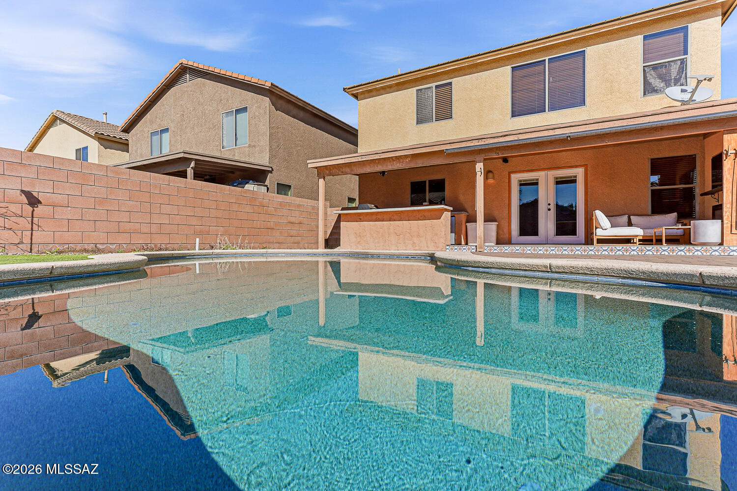 Welcome to your own private resort! This tastefully remodeled 4-bedroom, 2-bath home with a loft and sparkling pool is the perfect blend of comfort, style, and income potential. Light, bright, and beautifully infused with Mediterranean charm, this home is ideal as a private retreat or a high-performing short-term rental with an excellent rental history. The main level features sleek tile flooring and a modern, eye-catching kitchen with quartz countertops, designer backsplash, contemporary cabinetry,  stainless steel appliances, open wood shelving, and a breakfast bar perfect for easy mornings. The primary suite is conveniently located on the main floor, offering a walk-in shower and generous walk-in closet. Upstairs, unwind in the ultra-spacious loft, perfect for movie nights, a game room or additional lounging space, plus three additional bedrooms, two with walk-in closets, providing room for everyone. The remodeled guest bathroom includes a tub/shower combo, and washer and dryer are included for added convenience. Step outside into your backyard oasis designed for unforgettable gatherings, featuring an extended covered patio with wood ceiling, electric fireplace insert, built-in outdoor kitchen, paver decking, and a sparkling pool that truly completes the resort feel. Finished with modern lighting, updated fans throughout, a 2-car garage, and a prime location near the community park, shopping, dining, and I-19. All this with a low HOA of just $110 per quarter. This is more than a home, it's a lifestyle, an investment, and a daily escape. Don't miss your chance to own your own piece of paradise!
