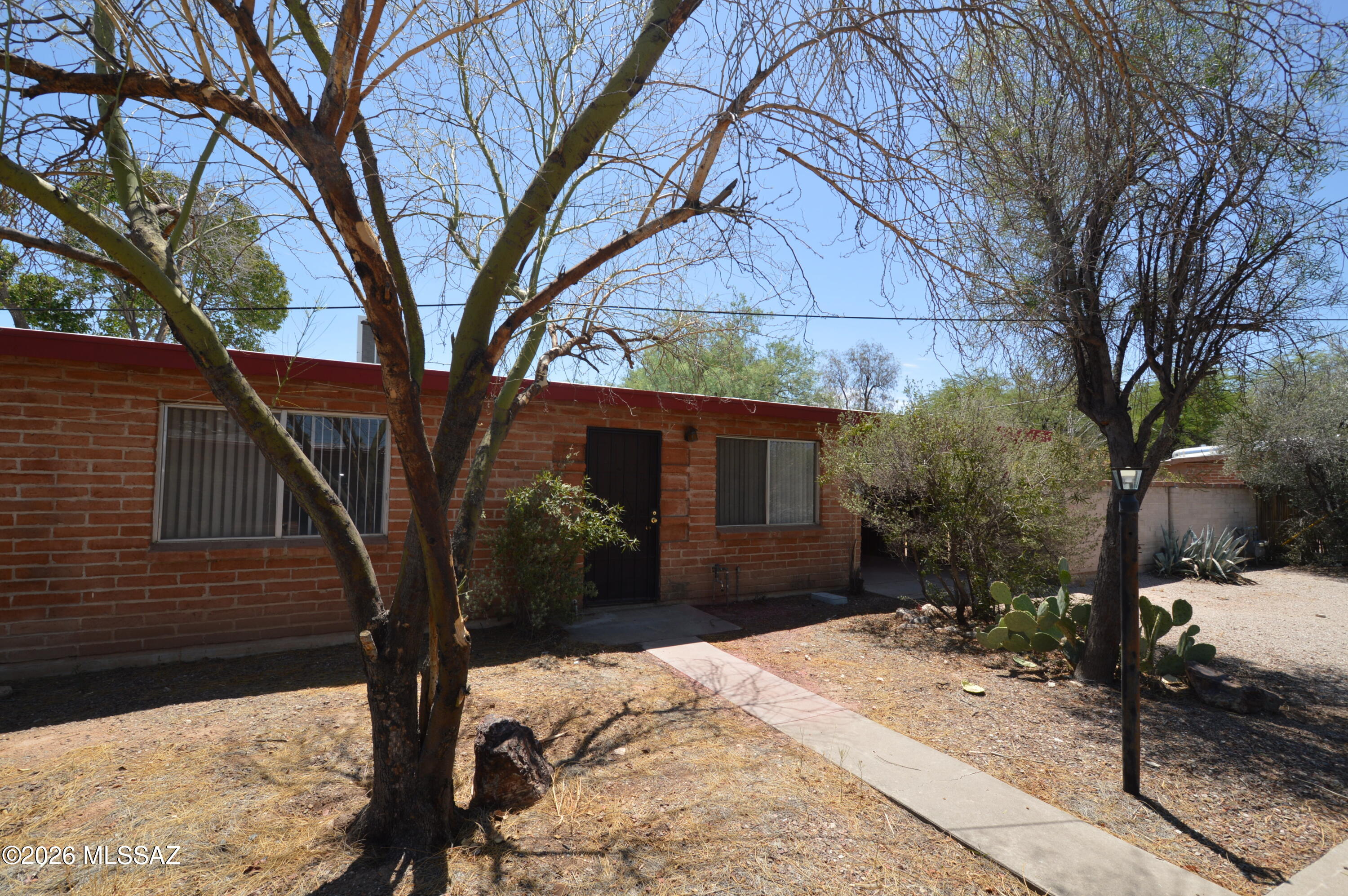 Spacious 2-bedroom duplex with beamed ceilings and lots of cool tile. Quiet and secure location, nestled in on cul de sac. Large walled yard, perfect for children or approved pet. Attached carport and personal laundry hook-ups. Large bedrooms and closets.  These units are rarely available, so CALL NOW!!