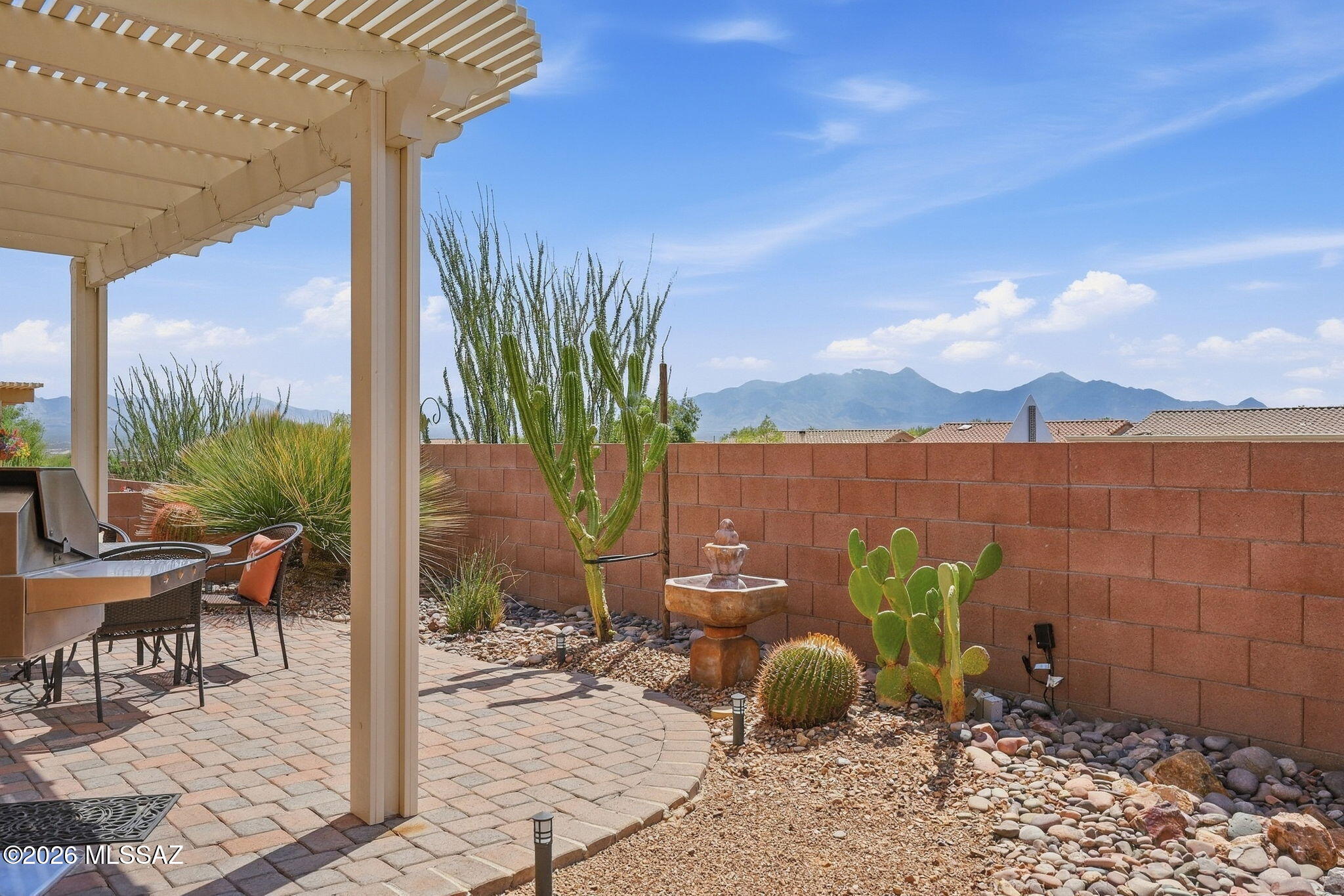 Fully furnished and truly turnkey, this impeccably maintained home in the gated Las Campanas neighborhood allows you to simply bring your suitcase and begin enjoying the Green Valley lifestyle. Centrally located near shopping, restaurants, entertainment and everyday conveniences, the home welcomes you with attractive low-maintenance landscaping, a covered front porch and an eight-foot security door. Inside, warm tile flooring, fresh paint, clean lines and quality furnishings create a comfortable setting for relaxing and entertaining. The open living, dining and kitchen areas keep everyone connected, while granite countertops, a raised breakfast bar, ample cabinetry, a double-bowl sink and modern appliances, including a gas range, make cooking and gathering a pleasure. A well-appointed office features a built-in desk, cabinetry, smooth countertops, freestanding bookcases and plantation shutters. The split-bedroom floor plan provides privacy, with a spacious primary suite offering a bay window, plush carpeting, a double vanity with cultured-marble countertops, a walk-in shower and an organized walk-in closet. Guests will appreciate a comfortable bedroom, generous closet space and a nearby bathroom with a tub-and-shower combination. A separate hobby room near the garage provides flexible space for creative projects, worktables or storage. The two-car garage also includes a laundry area and additional storage. Outdoor living shines with a covered patio, an attached wood-look aluminum pergola, an expansive pavered seating area and beautiful views of the Santa Rita Mountains, including Mount Wrightson and Mount Hopkins. The fully enclosed backyard features mature, low-maintenance landscaping and offers a private setting for grilling, entertaining or relaxing beneath Arizona's brilliant daytime and star-filled nighttime skies. Do not miss the opportunity to make this exceptional home your own--it is truly worth seeing in person!