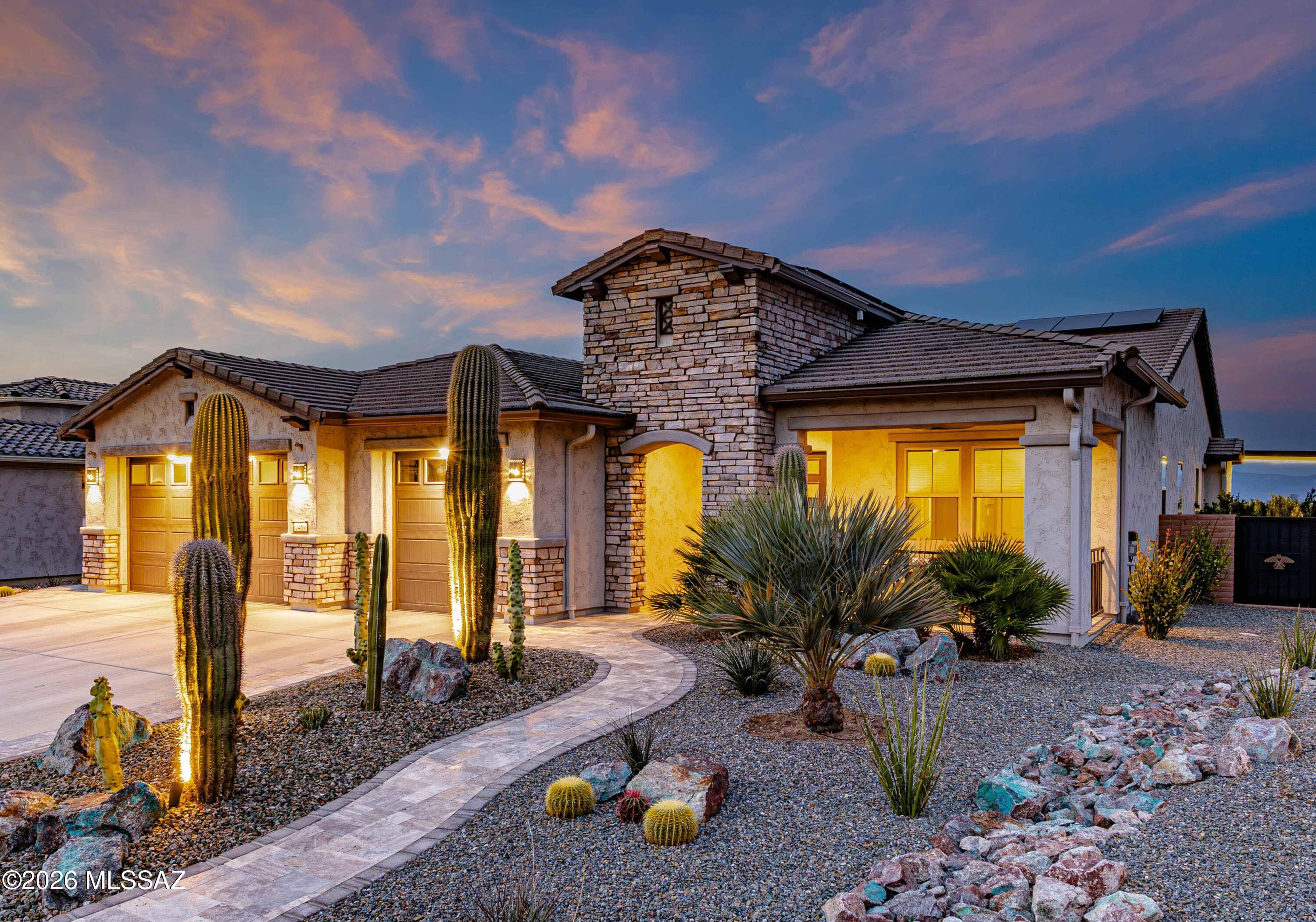 Luxury and tranquility can be yours in this lushly landscaped and meticulously appointed home in the highly-desired Sonoran oasis of Quail Creek in Green Valley!  Built in 2023 on an oversized north-south lot, this 2,726 sqft Avalon model captures open desert views in multiple directions, breathtaking mountain vistas, and vibrant sunrises and sunsets.
No expense has been spared in this elegant and immaculately-maintained retreat!  The home features 2 bedrooms and a versatile office/den that can serve as a third bedroom, 2.5 bathrooms all with luxury vanities and tile, a welcoming great room, expansive gourmet kitchen, dining room with built-in shelving, an oversized laundry room with stainless steel utility sink and cabinets for extra storage, and an air-conditioned 3-car garage. Silver travertine pavers frame the walkways and front patio, surrounded by a stacked stone facade on the home's exterior, and mature saguaro cacti and palms, all glowing with beautiful custom desert landscaping after twilight. Inside, an impressive glass-paneled entry door opens to a foyer that flows into a bright great room seamlessly connected to the kitchen, dining area, and outdoor living spaces. High-end finishes can be found throughout, including luxury vinyl plank flooring, coffered ceilings, quartz countertops, custom tile work, solid core doors, designer lighting, custom window coverings, and soft-close cabinetry in all rooms, each illuminated with natural light through each oversized window and expansive glass exterior doorway boasting tranquil views.  The gourmet kitchen is equipped with LG Signature appliances, including a 6-burner gas cooktop, convection/microwave ovens, wall-mounted hood, and dishwasher. An oversized quartz island, farmhouse sink, custom backsplash, butler's pantry, and large walk-in pantry provide both elegance and functionality. The dining room features a built-in buffet, large window overlooking the swimming pool and mountains, and sliding glass access to the patio. The primary suite offers direct patio access, a glass-enclosed custom tiled shower with bench, dual vanities, and a finished walk-in closet. Additional spaces include a second bedroom and bath, half bath, built-in office/den, and a well-appointed laundry room with LG ThinQ washer and dryer. The 3-car garage includes epoxy flooring, a 2-ton mini-split AC, whole-house water treatment, and a Rinnai tankless water heater. Leased solar panels significantly reduce energy costs. But the backyard living space is just as stunning as the home's interior!  Expansive sliding "Arizona" doors open to over 1,000 sq ft of covered outdoor living, finished in matching silver travertine. The backyard is a true resort retreat featuring a saltwater pool and spa with water features, Baja step, pebble-tec finish, and lighting. A covered outdoor kitchen includes premium Lion and Blaze grills connected to natural gas, along with refrigeration, storage, and generous counter space. A 60" lanai fireplace, rolling shutters and screens, and multiple ceiling fans will enhance your year-round comfort.  Lush desert landscaping with Canary Island Date Palms, decorative boulders, privacy walls, and custom gates complete the enclosed yard. Gutters drain underground to protect the foundation during monsoons. But don't forget about this highly sought-after neighborhood!  Residents of the gated Quail Creek community enjoy comfort, serenity, and world-class resort style living, including championship golf, multiple pools and spas, pickleball and tennis courts, fitness centers, arts facilities, on-site dining, walking paths, and an active social calendar -- all surrounded by the beauty of the Sonoran Desert and the Santa Rita Mountains.  This stunning home has been meticulously cared for and is waiting for you to call it your own -- today!