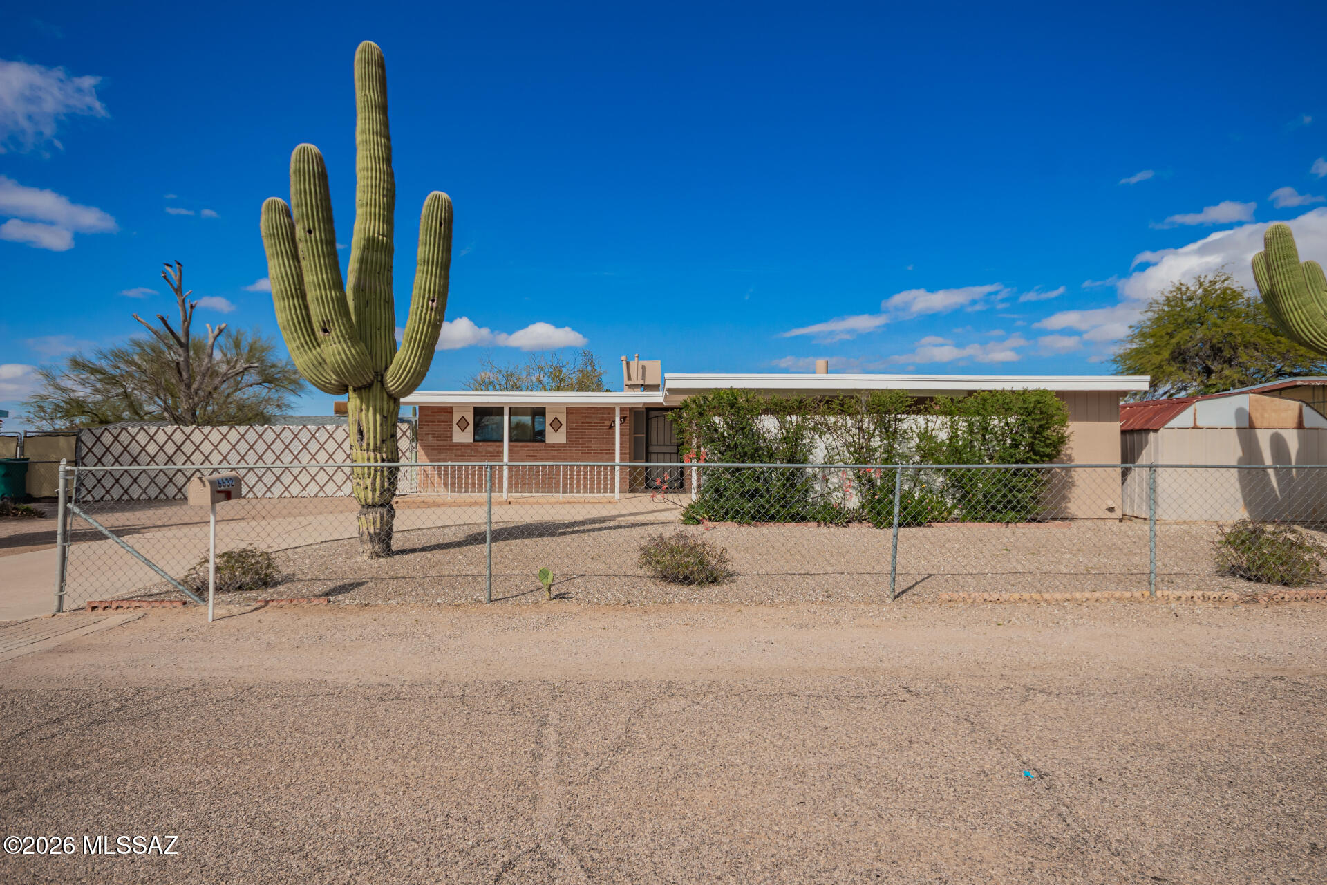 Welcome in to this charming mid-century modern home. Freshly painted interior and exterior deliver a bright, welcoming vibe, while the new roof ensures durability under Tucson's desert sun and adds long-term peace of mind. The classic exterior showcases iconic saguaro cacti, a timeless low-profile roofline (recently updated), and brick facade. Step inside to the open, airy floor plan that includes a spacious living room with a cozy fireplace and sliding glass doors leading to the backyard patio--ideal for soaking in those gorgeous Tucson sunsets.

The kitchen features modern cabinetry and plenty of counter space, perfect for everyday cooking or casual gatherings.

Generous bedrooms come with carpeted floors, ample natural light, and large closets (one offering a walk-in feel). The remodeled bathroom stands out with a dual vanity, fresh tilework, tub/shower combo, and separate shower stall for convenience.

A flexible bonus room serves as an ideal home office, den, hobby space, or extra sleeping area.

Outdoors, enjoy two side yards and a low-maintenance backyard with space for desert landscaping or relaxation.

Blending retro Tucson charm with fresh updates--including paint, new roof, remodeled kitchen, and bath--this move-in-ready gem is ready for its new owner--schedule your showing today!