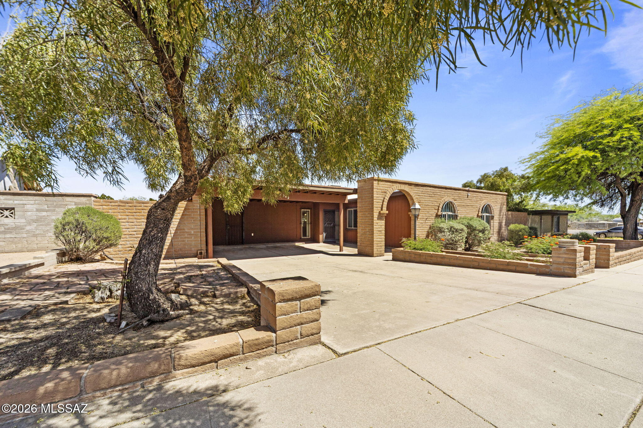 Charming Block home with separate shop/garage and back alley access. Located in Manzanita Terrace, this home has a quick commute to downtown Tucson, the Airport, and all the amenities, shopping and dining of the Central area. With a large 2 car car port, and extended shop area, the home is ready for your projects with no HOA. Updated kitchen highlights the parquet flooring. En Suite bath in primary and 3 good sized bedrooms. Separate living room, and dining area. Peaceful North facing back yard with large covered patio and shade, featuring workshop/garage access for those quiet evenings. Large mature shade tree and plenty of room for a pool if you are looking to expand!