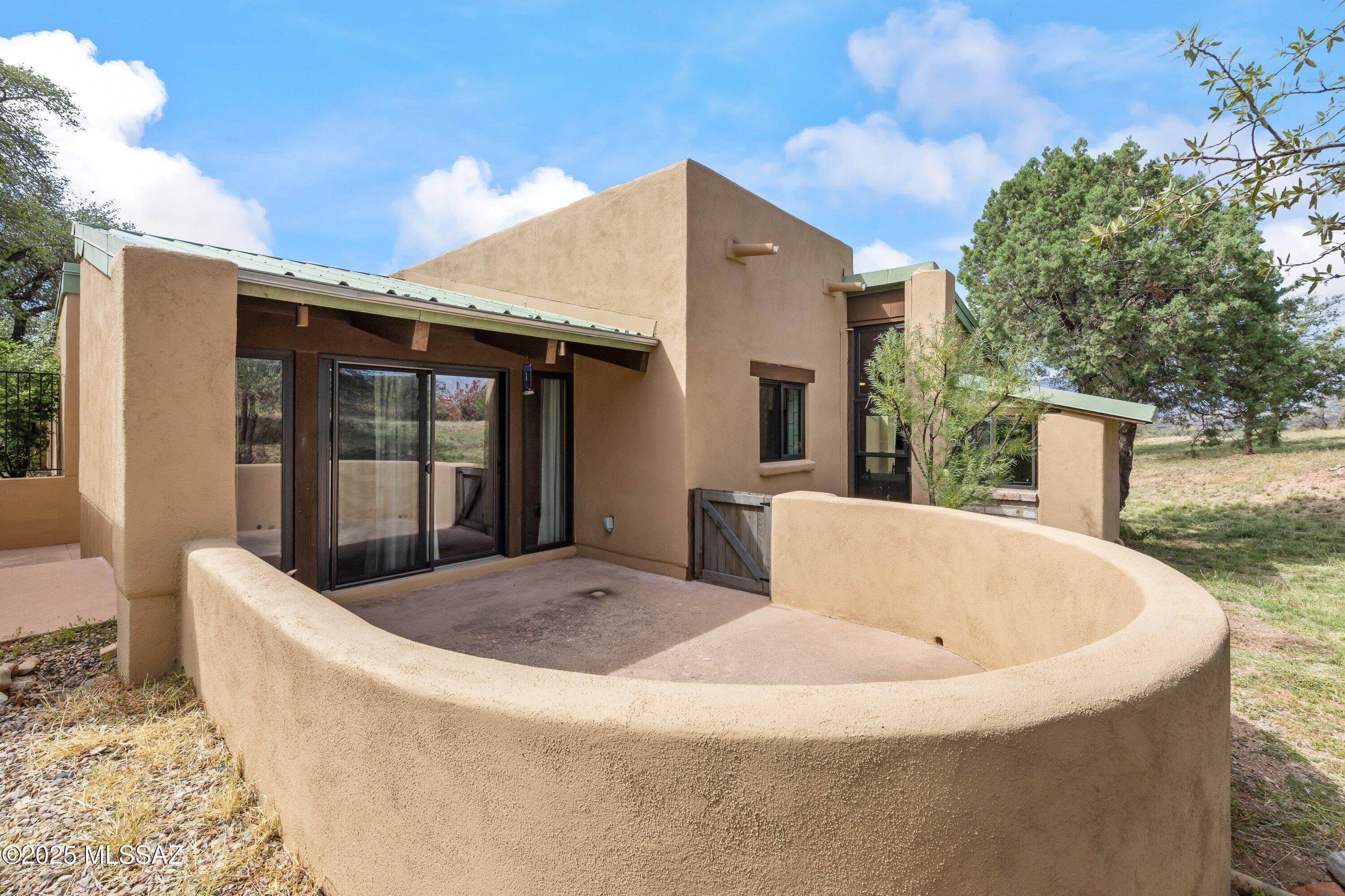 Welcome home to 50 Casas Arroyo, a tranquil retreat nestled in a quiet, private neighborhood in the heart of Sonoita, Arizona. This is more than just a house; it's a sanctuary where you can unwind and savor breathtaking mountain views from each of the four covered patios.

Crafted with exceptional skill, the home's interior and exterior walls are built from fired adobe block, with a classic stucco finish on the exterior, ensuring both beauty and durability. Step inside and be greeted by the warmth of a vaulted ceiling with tongue and groove planking, creating an open and airy ambiance. The heart of this home has been thoughtfully updated, with a substantial remodel completed just a few years ago. The modern kitchen is a chef's delight, featuring a tasteful blend of Majorca and subway tiles, polished concrete floors, and ample space for culinary creativity. The charm continues into the bathrooms, which also showcase beautiful tilework. You'll find elegant Saltillo tile flooring throughout the main living areas, while the bedrooms offer the plush comfort of new carpeting.

Comfort is paramount in this home, which offers a variety of heating and cooling options to suit any preference. A quiet and efficient dual-zone mini-split system with two indoor units provides targeted comfort, supplemented by a separate central ducted air conditioning system and ceiling fans throughout. For cozy evenings, gather around the pellet stove in the living room, or retreat to the master bedroom and enjoy the romantic glow of the kiva fireplace.

This home is not only beautiful but also practical. The recent remodel included a new metal roof, energy-efficient Anderson windows and sliding glass doors, and a tankless water heater for endless hot water. The water supply is from a regularly tested community well, providing peace of mind.

Storage will never be an issue, with an abundance of closets and storage space throughout the home, all illuminated by modern LED lighting. For your vehicles and hobbies, a detached two-car garage includes two large storage closets. Additionally, a separate studio building, complete with numerous outlets, electric heating, and ceiling fans, offers the perfect space for an art studio, workshop, or home office.

The property is a nature lover's paradise, with mature oaks, juniper, mesquite, and alligator spruce trees creating a low-maintenance, picturesque landscape. A dog door provides easy access to a fenced yard with a gate, giving your furry friends a safe place to roam. As part of this exclusive community, you'll enjoy access to a private pool and scenic hiking trails, all secured behind an entry access gate for your peace of mind and privacy.

To make your move even easier, the home conveys with black-out curtains, a refrigerator, and laundry appliances.

Don't miss this rare opportunity to own a piece of Sonoran paradise, where quality craftsmanship and modern amenities meet serene natural beauty. Your dream home at 50 Casas Arroyo awaits.