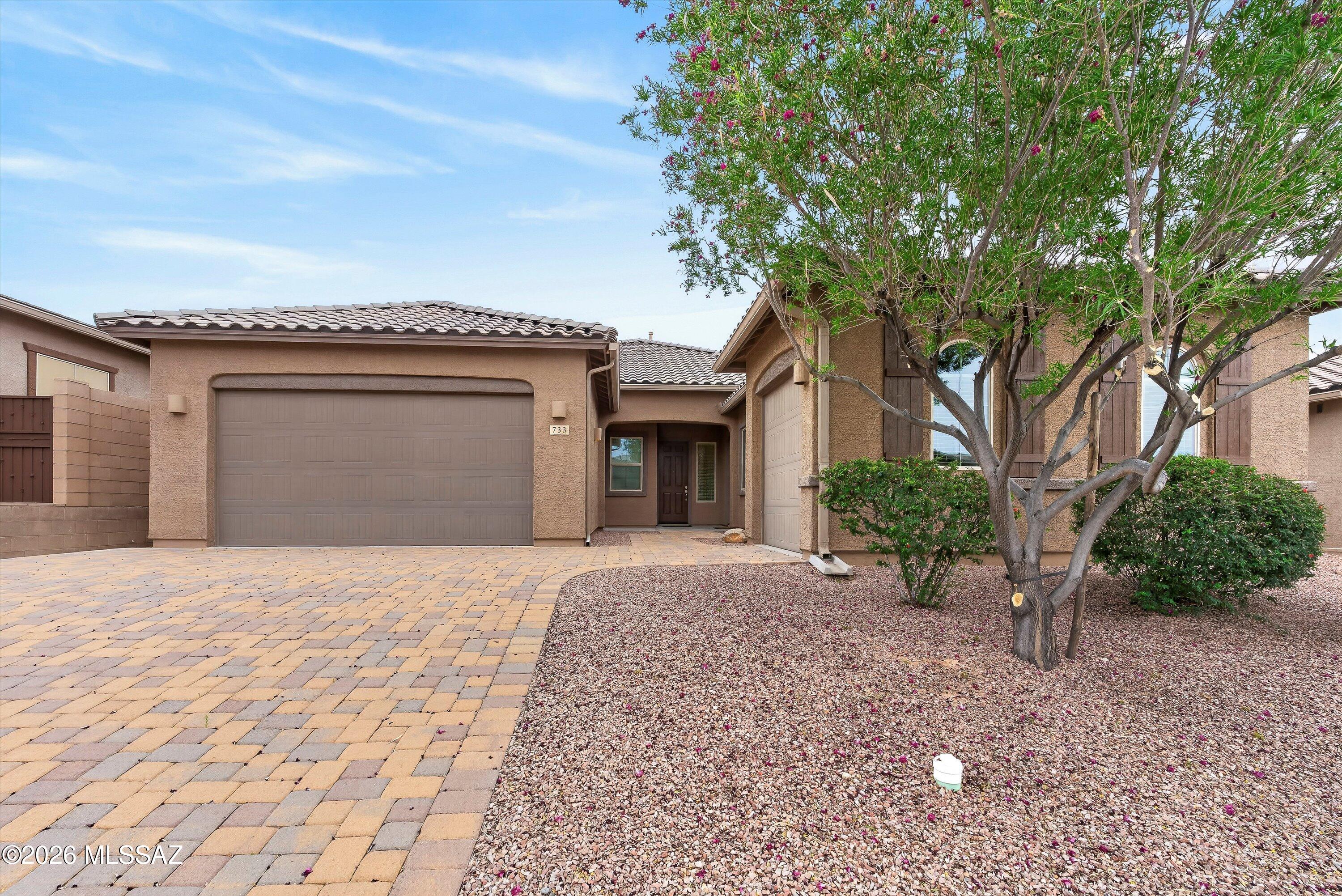 Experience the ultimate in modern versatility with this immaculate 4BD/3BA (2,594sqft) Next Gen home in the highly sought-after Eagle's Summit at Rancho Vistoso! Perfectly designed for multi-generational living, a high-end home office, or a private guest wing, this residence offers a unique ''home within a home'' with its own separate entrance, living area, kitchenette, bedroom, and bath. The main residence welcomes you with a light-filled, open-concept floor plan featuring soaring ceilings, plantation shutters, and upgraded flooring throughout. The gourmet kitchen is a chef's dream, boasting rich granite countertops, a large social island with a breakfast bar, professional stainless appliances (including double ovens and a gas cooktop), and a spacious walk-in pantry. Whether you're hosting large holiday gatherings or enjoying a quiet night, this space is designed to impress. The primary suite serves as a serene sanctuary, featuring a private patio exit, dual vanities, and a luxurious walk-in shower. Outside, your private backyard oasis awaits. Relax under the deep covered patio finished with elegant travertine pavers, low-maintenance turf, and custom privacy screen, all while enjoying the rugged silhouette of the nearby Catalina Mountains. Practicality meets luxury with a finished 3-car garage (including a utility sink) and a location that is truly unbeatable--just steps away from Hohokam Park's tennis courts, playgrounds, and dog park. This move-in-ready masterpiece offers the space, style, and community lifestyle you've been searching for in Oro Valley.