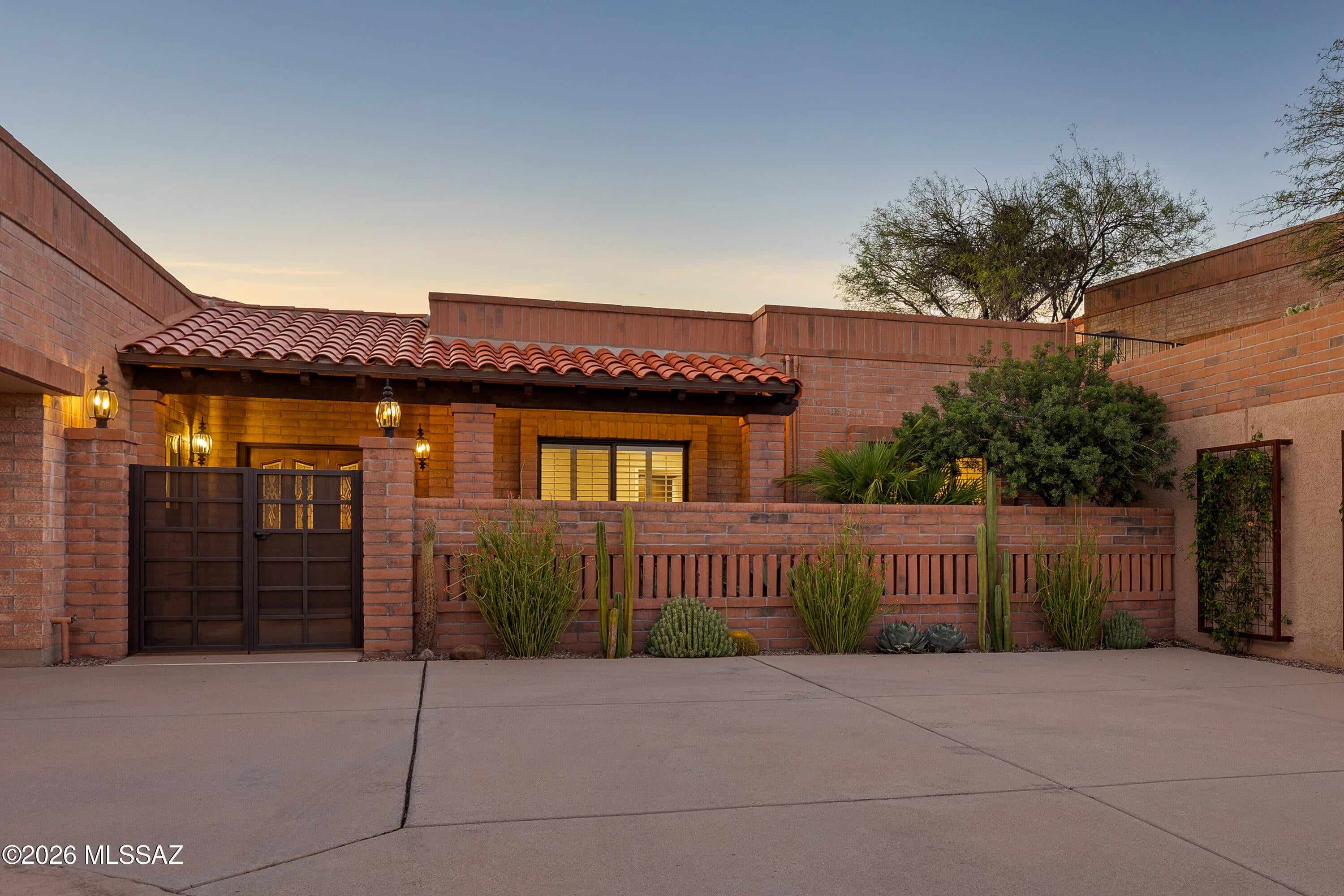 Fully renovated and expanded in 2019, this stunning Fairfield townhome in the Catalina Foothills delivers luxury living at every turn. The spacious chef's kitchen dazzles with KitchenAid appliances, custom cabinetry, and an expansive center island with seating for six, flowing seamlessly into a cozy TV space. The open living and dining room impresses with soaring ceilings accented by architecturally stunning wood-beams, a stacked stone, gas burning fireplace, and floor-to-ceiling windows framing the private updated pool with city, sunset and mountain views. The custom wet bar with wine cooler adds to the seamless flow of the entertainment spaces. The elegant primary suite is a true retreat, featuring a spa-like bath with soaking tub, custom-designed walk-in closet, and sliding doors to a private patio with pool access as well as a private office adding versatility to this intimate space. The guest suite offers a custom walk-in shower and custom closet storage; a third bedroom with custom closet and a hall bath with integrated tub and shower complete the private areas of this stunning home. The exterior of the home was fully updated in 2020, and offers privacy, multiple patios inviting al fresco dining, lounge areas and an upper deck with custom firepit and expansive views. The entry courtyard with custom gate and sitting area provides a private space to capture Tucson sunrises. No detail has been overlooked, including 24" tile throughout, custom shutters and blinds, replacement of windows and sliding doors in 2019, and a 3-car garage with expanded overhead clearance and separate storage room.