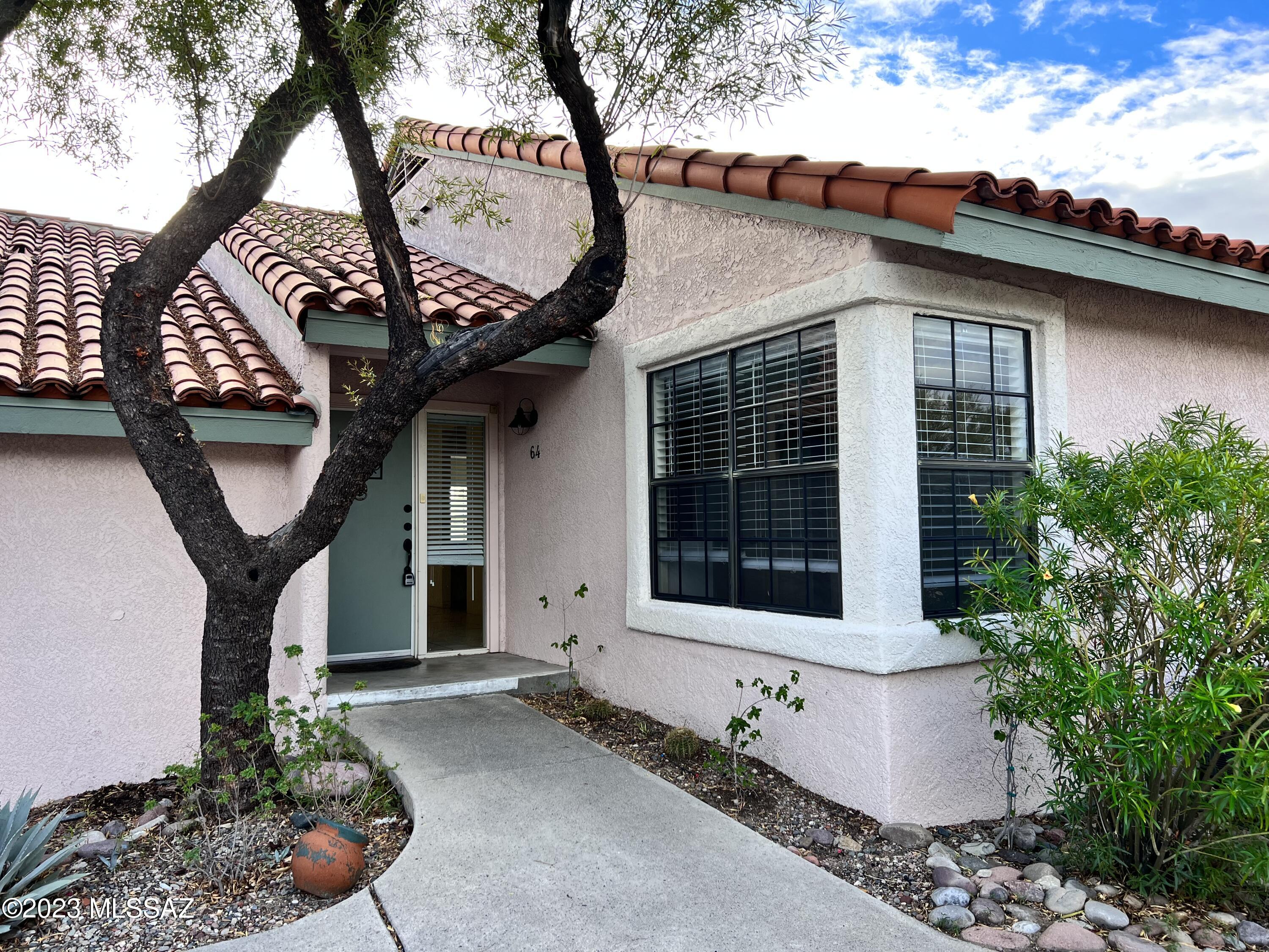 Located in the Catalina Foothills, minutes to La Encantada Mall, this 2bdr/2ba single floor condo is all on one level but feels like it is on the second floor due to the hillside location! Private patio offers mountain and city views. Spacious ceiling room w/vaulted ceilings and fireplace, kitchen offers lots of cabinets and counter space w/an additional bar sink. Dining area overlooks patio and there is another space that could be used for sitting area or dining. Primary bedroom has walk-in closet w/ensuite that features dual vanity and shower. Hall bath has tub/shower.