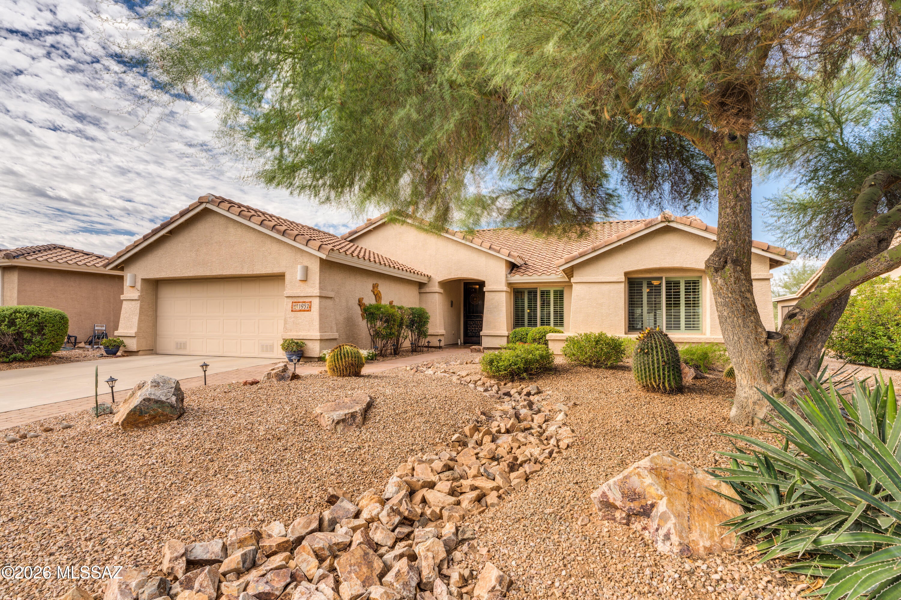 Experience exceptional privacy and outdoor living in this Montana model, ideally positioned on a premium Quail Creek homesite overlooking a wooded desert arroyo with no rear neighbors. Offering 2,195 sq. ft., 2 BR, 2 BA and a Den, the home is designed for comfortable living with versatile interior spaces, an updated kitchen and a tranquil natural setting. Native plantings create inviting curb appeal and lead into the foyer, where an expansive great room provides multiple options for living, dining and entertaining. Plentiful windows frame views of the mature vegetation and arroyo beyond. The updated kitchen features cherry cabinets, granite counters, tile backsplash, pantry closet and stainless appliances, including a gas range with vent hood. The adjoining breakfast nook and bay window provides abundant light and an ideal setting for casual dining, while a built-in desk helps keep household tasks organized. The spacious owner's suite also enjoys views of the backyard and arroyo from its bay window, along with direct access to the rear patio. The main bath includes dual vanity with glass vessel sinks, an all-tile walk-in shower with a glass-block surround and a large walk-in closet. The split-bedroom floor plan provides privacy for guests, with an adjacent full bath for added convenience, and the guest bedroom includes a wall bed, allowing it to double as a hobby or multipurpose room when visitors are away. A separate den off the entry offers additional space for an office, library or media room. 
 
Outdoor living is a highlight, with a covered rear patio featuring ceiling fans, an extended paver patio and a peaceful water feature. Mature trees, shrubs and desert plantings create a private retreat overlooking the arroyo--an ideal setting for birdwatching and occasional visits from native wildlife. Additional features include a laundry room with extra storage and a utility sink, a new roof in 2018 and zoned HVAC with both units replaced in 2021. This distinctive home offers generous living space, privacy and an exceptional connection to the Sonoran Desert.