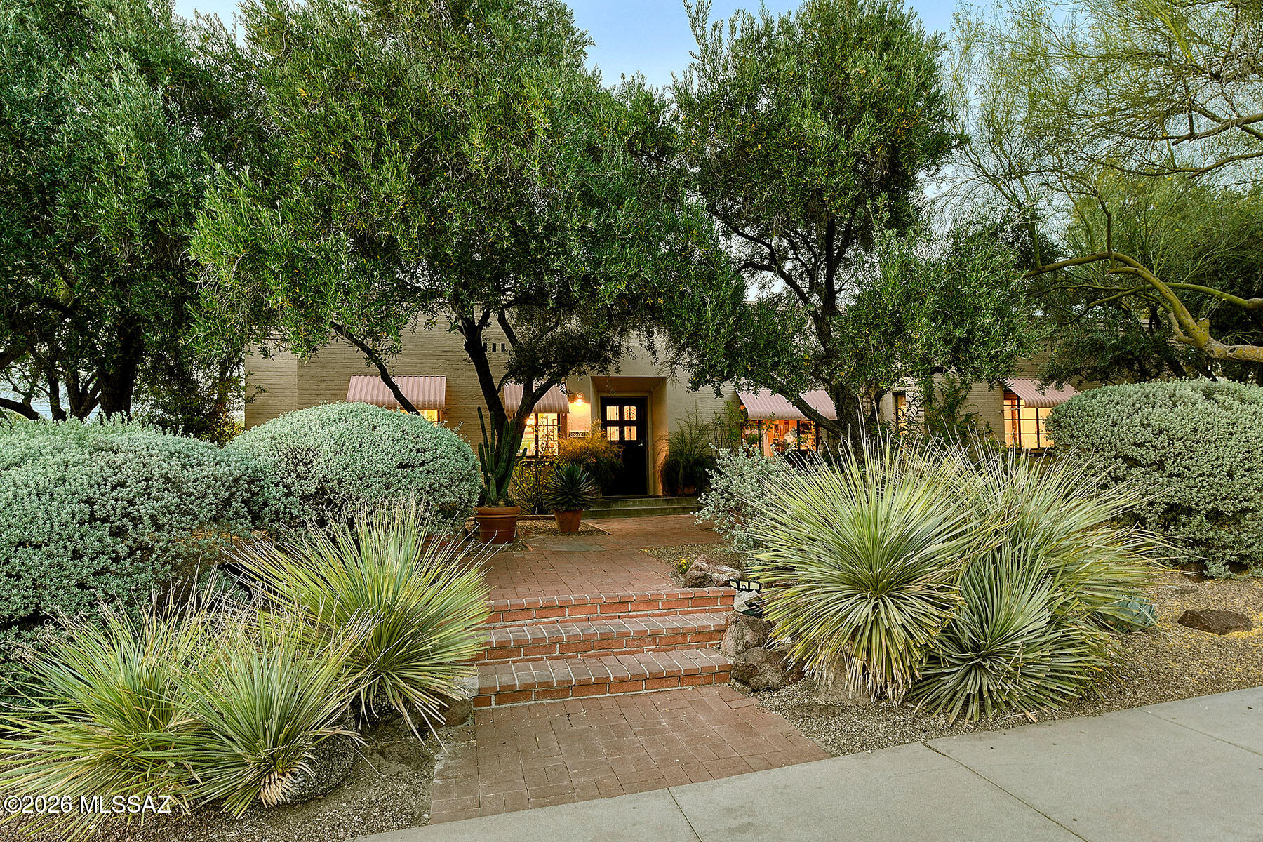 Thoughtfully reimagined and extensively upgraded, this beautiful 1940s Territorial home in Sam Hughes offers 2643 sq.ft. with 4 bedrooms and 3 bathrooms, along with character, comfort, and everyday practicality. The heart of the home is a stunning, fully reconfigured kitchen and dining area, where walls were removed to create an open, inviting space for everyday living and entertaining while retaining elements of the original character. The kitchen features all new GE Cafe appliances, custom all-wood cabinetry, easy access drawers, quartz countertops, designer tile backsplash, and new tile flooring. Thoughtful details include a walk-in pantry, corner lazy susan storage, built in pot racks, and layered lighting with pendant, recessed, and under cabinet illumination. The adjacent laundry room has storage and an extra sink for convenience. 
Original fir hardwood floors, beautifully refinished, as well as built-in bookcases preserve the home's charm and character, with upgrades like newer HVAC system and new, restored fireplace chimney. 
Step into the backyard to a truly exceptional outdoor environment, professionally landscaped with beautiful pebble tech pool, large shade pergola, lush low-maintenance planting, extensive stained cement and custom brick patios, with the addition of layered lighting creating an elegant outdoor entertainment space. The pool has upgraded new coping, enhanced circulation, new pump, automatic filler and solar heating for extended seasonal use. The garden was expanded by approximately 480 sq.ft. with a new engineered masonry back retaining wall, multiple gates and new cement stairs for easy alley access. A new custom brick wall enhances privacy from the carport. The new irrigation system is customized and flexible for adding additional plant pots as desired.
The front yard showcases over 60 newly planted, predominantly native plants, anchored by beautiful mature olive and palo verde trees. 
A detached studio adds valuable living flexibility with new vinyl flooring, its own mini-split HVAC system, stacked washer/dryer,  new water heater, fresh paint and full bathroom. 
Additional features include Tuff shed for storage and secure metal carport gate.
Perfectly located within walking distance to Himmel Park, library, restaurants, local elementary school and the UArizona.