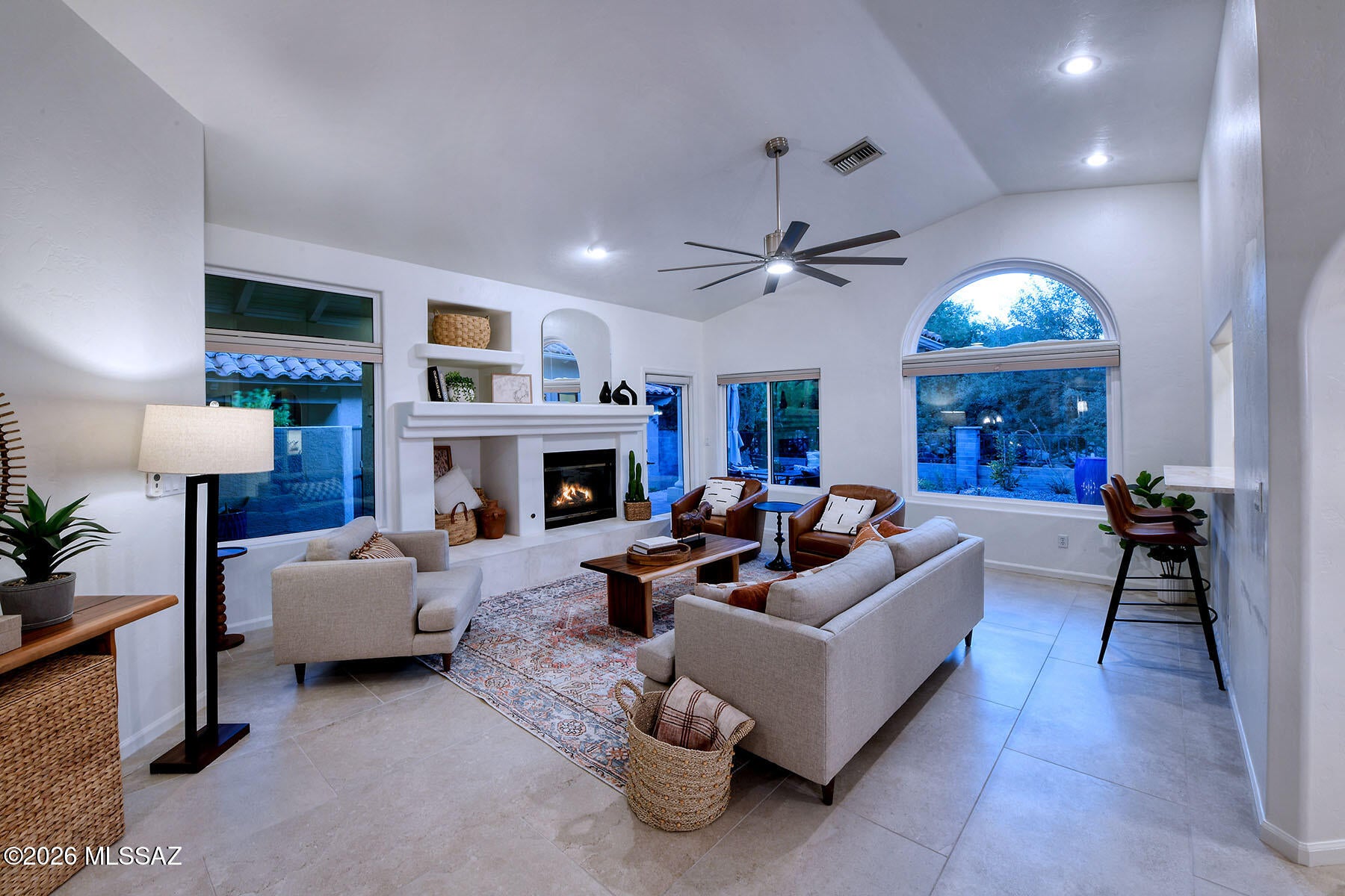 Welcome to an exceptional retreat in the sought-after community of Las Ventanas, a charming enclave adjacent to Ventana Country Club where the beauty of the Sonoran Desert meets an effortless resort and golf lifestyle. Set against breathtaking Catalina Mountain views, this beautifully renovated three-bedroom residence offers the rare combination of sophisticated design, relaxed elegance, and lock-and-leave ease. The open floor plan, soaring ceilings, and expansive windows create a light-filled setting that feels both grand and inviting, while the spacious dining area frames spectacular mountain vistas--perfect for leisurely dinners or entertaining friends after a day on the course. The completely reimagined kitchen is a true showpiece, featuring Schrock cherry cabinetry with a rich buckskin stain, Taj Mahal quartzite countertops, Bosch appliances, a Franke workstation sink, and Brizo fixtures, all complemented by beautiful Borgo porcelain flooring throughout. The luxurious primary suite continues the refined aesthetic with a beautifully remodeled bath featuring Ultracraft cabinetry, a frameless glass walk-in shower, Toto toilet, Hansgrohe fixtures, Invictus Italian tile, and a sophisticated LG WashTower. The secondary bath has been thoughtfully upgraded to the same exceptional standard. Throughout the home, Anlin SunMatrix windows and honeycomb cellular shades provide comfort and style, with Hunter Douglas remote-operated shades enhancing the dramatic arched windows. Outdoors, Horticulture Unlimited transformed the private patio into a serene desert oasis with elegant pavers, landscape lighting, drip irrigation, and lush, thoughtfully selected desert plantings. A new roof in 2024 adds further peace of mind. Residents of Las Ventanas enjoy a community pool and spa, sidewalks, mature desert landscaping, and an enviable proximity to the amenities of Ventana Country Club. This is more than a beautifully renovated home--it is a sophisticated desert retreat designed for savoring mountain sunsets, enjoying the golf lifestyle, gathering with friends, and embracing everything Tucson's Catalina Mountain setting has to offer. Simply put, this is one of the most beautiful and tastefully appointed homes imaginable.
