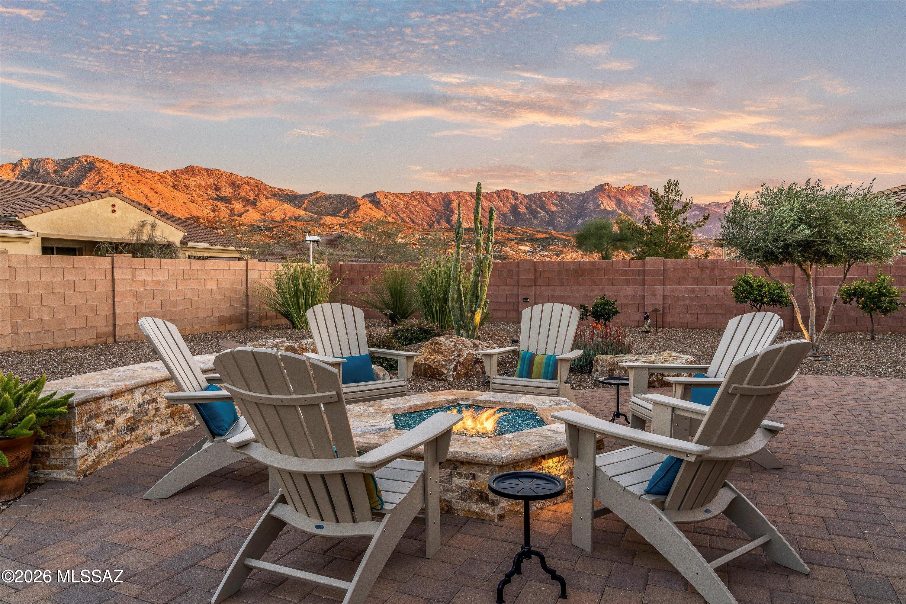 Located in The Preserve at SaddleBrooke, this refined Paloma model offers exceptional indoor and outdoor living on a spacious lot with a true resort-style setting. The backyard is designed for entertaining and relaxation, featuring a pool and spa with attached umbrellas and gas heater (2021), gas firepit, multiple patio seating areas, an extended covered patio with TV, and dramatic outdoor lighting. Inside, the home showcases a bright great room layout with kitchen, living, and dining spaces flowing seamlessly together beneath high ceilings and large Milgard windows. The chef's kitchen is highlighted by black slate Café appliances, a custom vent hood (gas range), stylish backsplash and a custom pantry. Two bedrooms feature private ensuites, complemented by a stylish updated powder room. The primary bathroom was remodeled in 2022. Additional highlights include owned solar, custom iron entry doors, new HVAC (2025), extended garage, and a thoughtfully designed laundry room that doubles as a pet retreat. Fresh exterior paint in 2024 and designer-selected finishes throughout, including upgraded paint tones, window blinds, lighting, and fans, complete this truly one-of-a-kind home.