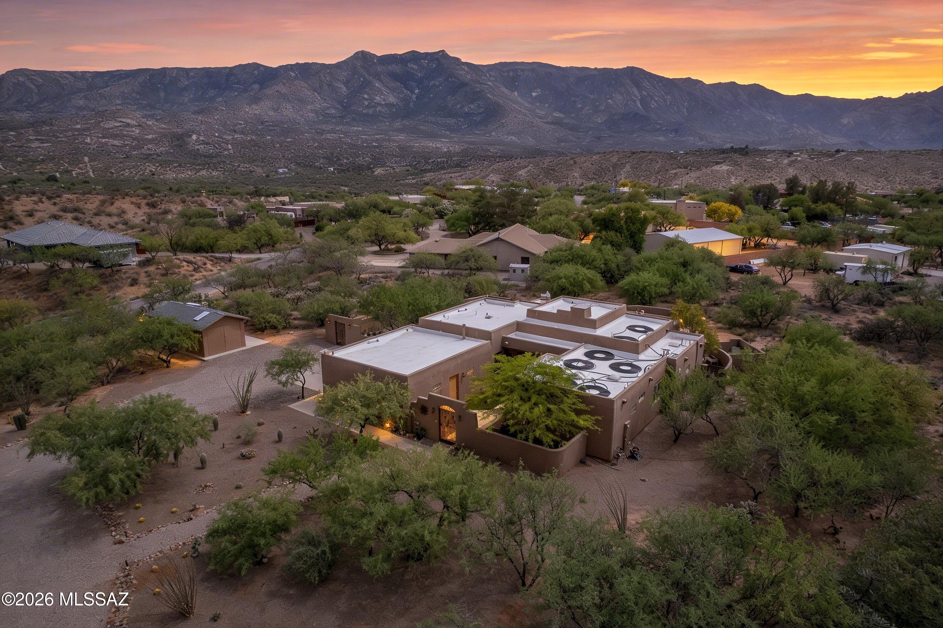 Experience breathtaking Catalina Mountain views from this beautifully crafted Santa Fe retreat--where rich Southwest details and refined finishes come together on a private 1.1-acre desert lot in Mountain Vista Estates with no HOA.
From the moment you arrive, the home sets the tone. A gated courtyard entry with authentic Santa Fe architectural details, a custom entry gate, solid wood doors, warm desert tones, and handcrafted accents creates a sense of arrival that feels intentional, inviting, and distinctly Arizona.
Inside, the main living area showcases the home's architectural character with exposed viga beam ceilings, warm natural finishes, and an open-concept great room design. A full wall of glass frames the Catalina Mountains and opens seamlessly to the covered patio, creating a true indoor/outdoor living experience. Custom wood detailing, including hand-crafted corbels and architectural accents, adds depth and authenticity, while the vaulted ceilings and natural light enhance the sense of space and comfort.
The kitchen is a true centerpiece--equal parts function and artistry. Custom Acacia wood cabinetry, quartz countertops, stainless appliances, and a gas range are complemented by a custom hand-painted Talavera tile mural by artist Carly Quinn, bringing vibrant color, craftsmanship, and a one-of-a-kind Southwest focal point to the space.
The primary suite offers a peaceful and private retreat, with direct access to the backyard and mountain views that carry through the room. The ensuite bath features a soaking tub, dual vanities, a separate shower, decorative tile finishes, and a walk-in closet--designed to feel both refined and relaxing.
Two additional bedrooms are connected by a thoughtfully designed Jack & Jill bathroom, offering both privacy and functionality. An additional full guest bathroom with a walk-in shower is conveniently located near the main living areas--ideal for visitors or flexible living arrangements. The den easily functions as a fourth bedroom, office, or creative space depending on your needs.
Step outside, and this is where the property truly shines. The backyard is a private desert retreat--fully walled and thoughtfully designed with a PebbleTec pool featuring a waterfall, travertine hardscape, multiple seating areas, artificial turf, and mature desert landscaping. The full-length covered patio spans the back of the home and features a gas fireplace with a matching custom tile installation by Carly Quinn, creating a seamless extension of the home's design and character. Both the front courtyard and backyard incorporate low-maintenance turf, enhancing usability while maintaining the natural desert aesthetic.
And through it all--the constant backdrop--the Catalina Mountains.
Additional features include RV parking, natural gas, new HVAC, double-pane windows, a two-car garage, a detached storage shed, and a private gated entry to the backyard. Located on a county-maintained paved road with no HOA.
Located in the highly sought-after Amphitheater School District (Coronado K-8 and Ironwood Ridge High School), this home offers a rare combination of privacy, land, architectural character, artistic detail, and elevated desert living in one exceptional property.

Homes like this don't come up often--and when they do, they don't last.