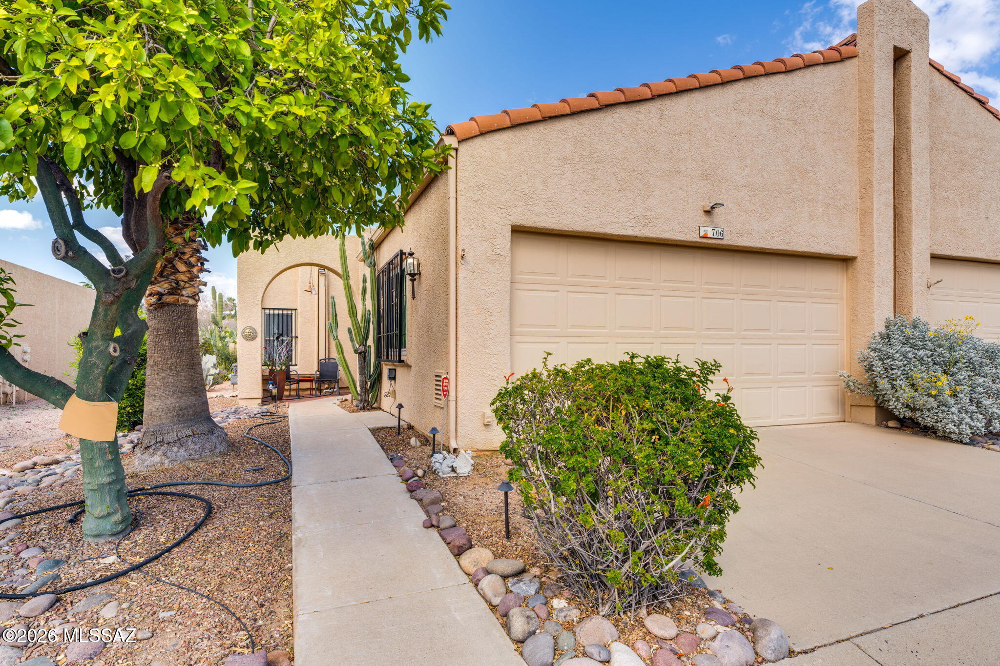 Located in the beautiful Sunset Ridge community in NW Tucson, this meticulously maintained 2-bedroom, 2-bath townhome is bright and inviting with tile flooring throughout--no carpet! The open great room features a dining area, spacious living room, and cozy fireplace for cool desert evenings. The kitchen offers abundant counter space and storage. Large sliding doors lead to a covered paver patio and a low-care desert landscaped backyard. The 2-car garage includes epoxy floors and ample storage. Newer HVAC and roof recoated in 2025. Enjoy community amenities including two pools, two hot tubs, and a recreation center with fitness facilities. Conveniently located near shopping and restaurants in a quiet, well-kept neighborhood. Don't miss out on  this beauty, call today!