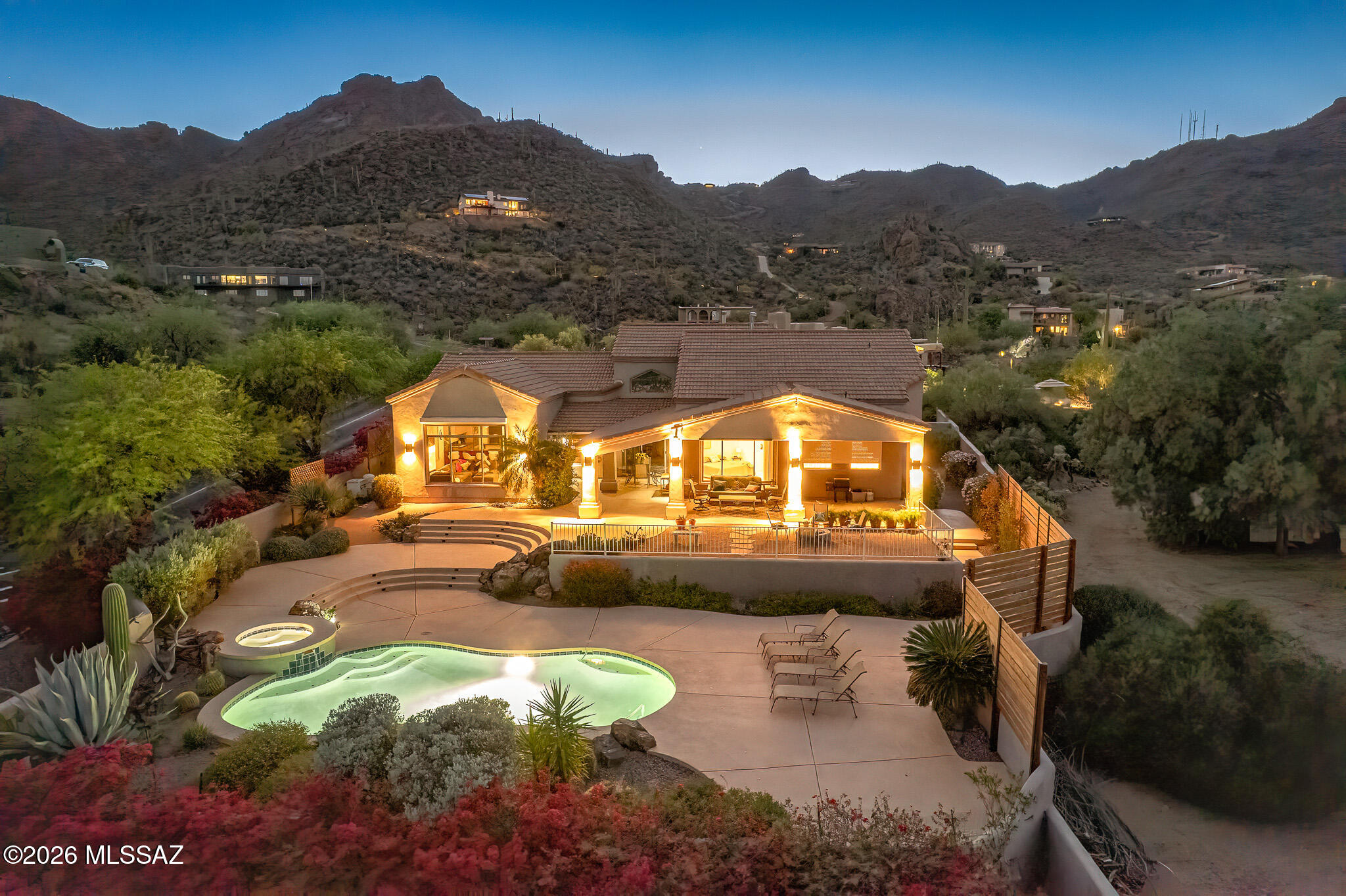 Nestled within a canyon in the highly coveted gated community of Trails End, this exceptional residence offers resort-style living where luxury meets the Sonoran Desert. Panoramic desert vistas and twinkling city lights are framed by hot pink bougainvillea and the crisp blue water of the pool, spa, and waterfall in the foreground. Soaring ceilings, oversized custom windows, and intentional design make the view the star of the show in nearly every room of the home. A cohesive attention to detail and style is reflected in the granite countertops, 16'' tile, and knotty alder cabinetry, doors, and built-ins throughout. Situated on one of the most sought-after lots in Trails End, this property is not only uniquely exempt from the HOA, it also features rare, expansive, flat, and accessible acreage perfect for RVs and guest parking.

The current owners remodeled the powder room and enclosed the sitting room in the primary suite making it the perfect place for a nursery or den.
The home also has a new dishwasher, and newer variable speed pool pump, washer/dryer, and water heater. Minutes from hiking trails, 10 minutes to the JW Marriott and Country Club, and less than 20 minutes to downtown. See the list of features and upgrades for more details.