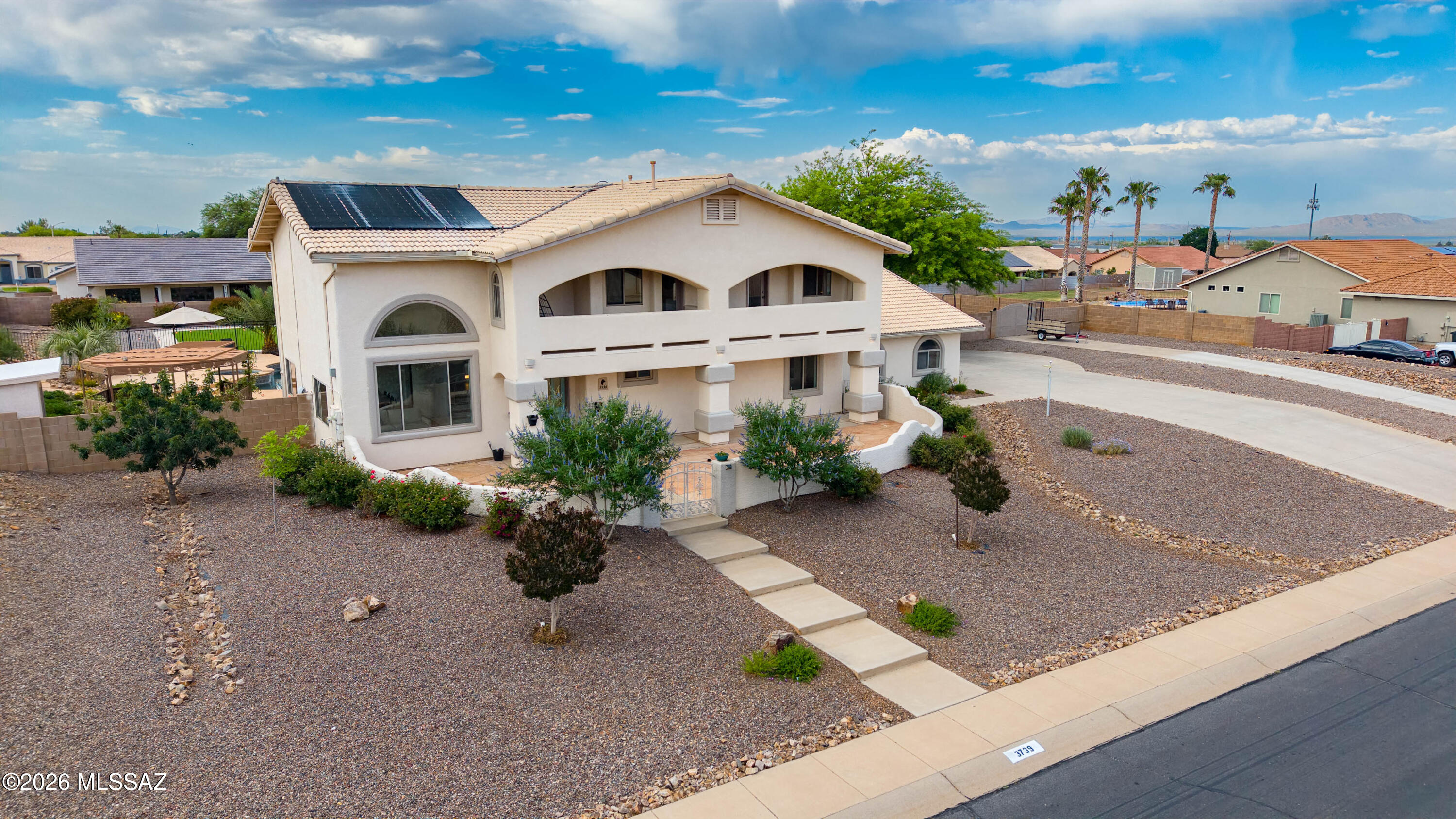 Perched on 0.8 acre in Canyon de Flores, this stunning 5BR/3BA two-story solar home offers luxury, space, and unforgettable mountain views! Enjoy breathtaking sunrises and sunsets from the flagstone courtyard or multiple private balconies. Inside, soaring ceilings, abundant light, two spacious living areas, and a gourmet kitchen w/granite countertops & luxurious wood cabinetry, double ovens, stainless appliances, breakfast bar, & walk-in pantry blend elegance and comfort. The spacious primary suite features a huge private balcony and spa-like bath. Backyard oasis includes pool, spa, separate pergola space, huge turf play space, raised garden, playground, storage shed, w/ dual driveway access to the backyard and space to park the RV. Close to shopping, schools, and Ft Huachuca.
