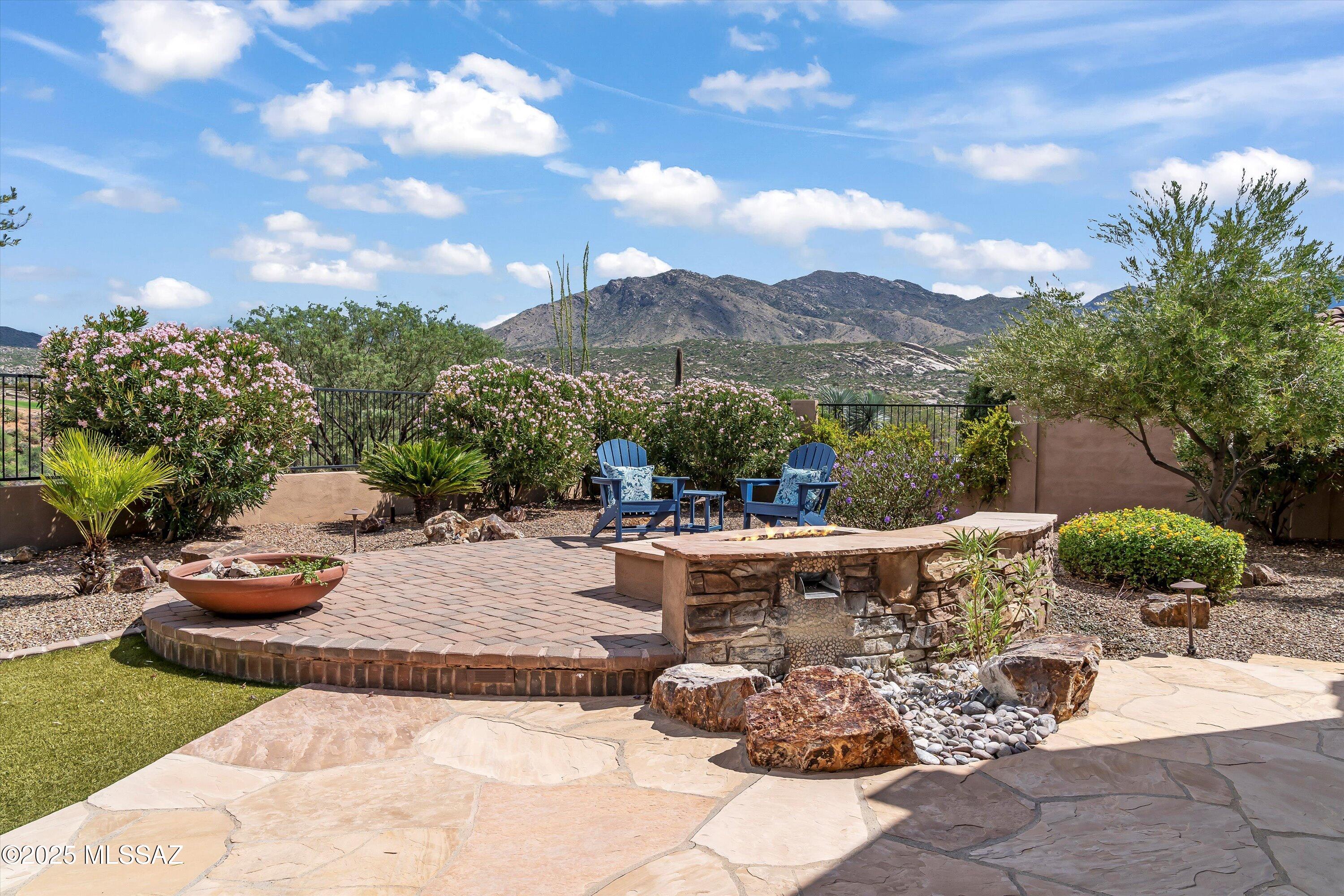 This upgraded and modified Sabino model offers expansive golf and mountain views, featuring three bedrooms and 3 bathrooms. Elegant wood flooring leads into a welcoming great room that overlooks lush backyard landscaping, set against the backdrop of the golf course and mountains. The stylish fireplace is perfect for cool evenings. The open kitchen provides ample counter and cabinetry space, stainless steel appliances, granite countertops, and a cozy sitting area ideal for morning coffee or quiet reflection. The spacious Owner's Retreat includes a comfortable lounge area with scenic views, and an en-suite bathroom with dual vanities, a soaking tub, a separate walk-in shower, and a customized walk-in closet. The second bedroom suite also enjoys sweeping views, a walk-in closet, and its own en-suite with a tiled shower. The den may serve as a guest room and is complemented by an additional bath. Outdoor living is enhanced by a large, covered patio and an expanded raised patio with a custom firepit and built-in seating. Maximizing privacy and panoramic views, the generous yard is well-suited for entertaining and relaxation, offering the perfect setting to experience the dynamic landscapes and premier lifestyle of SaddleBrooke Preserve.