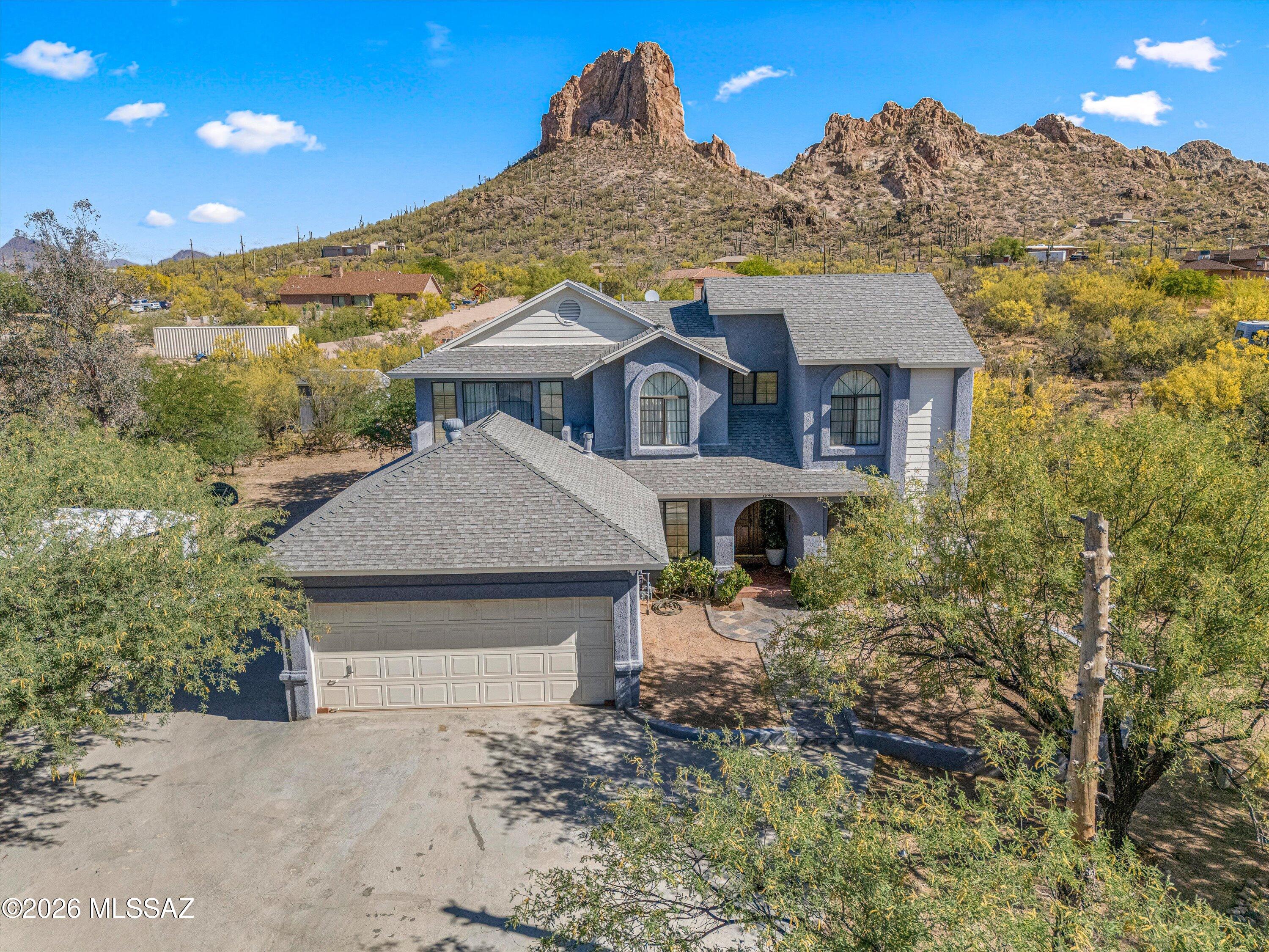 Custom built one owner home on 1 full acre! First time on the market this special home has everything you need: 4 bedrooms, 3 full bathrooms, 2,036 sq ft on 1.04 acres. Room for all your toys and parking. 2 car attached garage with storage and a utility sink. One car detached carport with storage. Parking for RV or boat with septic clean out, power and water. Covered patio in the back with built in BBQ and fire pit with seating to take in views of Beehive Peak. Inside you will find a spacious kitchen with granite counter tops and breakfast bar. Primary bedroom with walk in closet, private bathroom with soaking tub, double vanities and shower. Primary bedroom has balcony to take in the views of Tucson and mountains. Sunken living room with fireplace and wet bar. NO HOA! Formal dining room and family room too. Bedroom on the main level and then 3 more upstairs. Gated entry for extra privacy. The front yard features mature landscaping and offers privacy. Storage shed in the backyard too. This is a special home!  Come see it before it is gone!