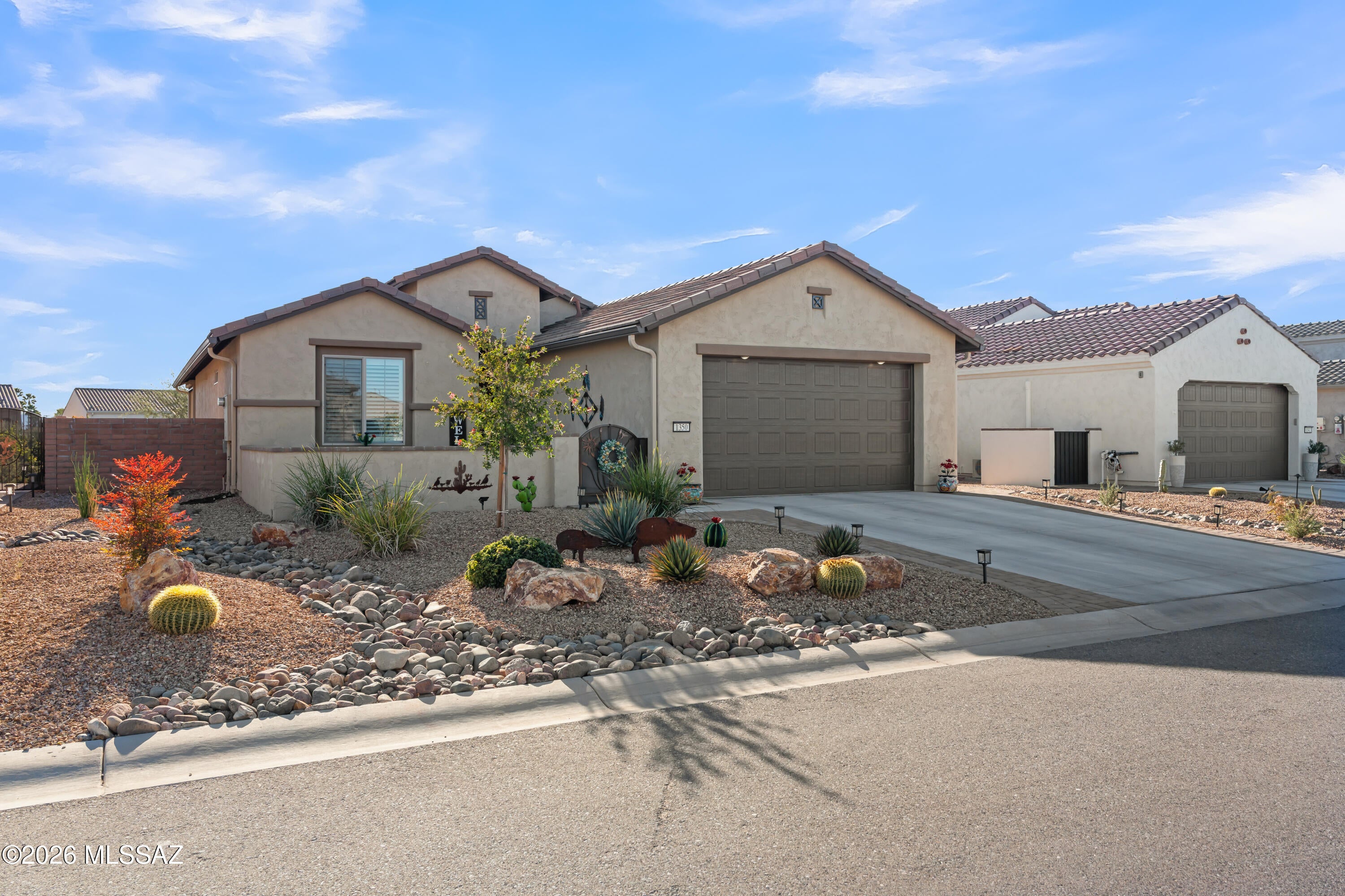 Welcome to Quail Creek Country Club, a premier 55+ Robson Resort community nestled in the foothills of the Santa Rita Mountains. Situated at an ideal 2,979-foot elevation, this nearly new home offers refined desert living, exceptional privacy, and the active-adult lifestyle Quail Creek is known for.
A spacious enclosed front courtyard creates a welcoming outdoor entry, accented by elegant wrought iron and copper gates. Across the street, a beautifully maintained common area enhances the open, park-like setting.
Inside, the open-concept great room brings together living, dining, and entertaining spaces, highlighted by a wall of windows framing beautiful desert, mountain, and distant city-light views. The kitchen has been refreshed with new granite countertops, updated hardware, and stylish light fixtures, while both bathrooms also feature new granite counters. The guest bath has been further upgraded with a beautiful new tile shower. Ceramic tile flooring throughout, custom interior paint, and updated designer lighting add to the polished feel.
The split-bedroom floor plan provides privacy, while a den, back bar, and flexible living space offer room for guests, hobbies, or a home office.
Step outside to the extended covered rear patio with solar-powered roll-down screens, perfect for enjoying Arizona's indoor-outdoor lifestyle year-round. The backyard borders a peaceful bird and wildlife corridor, providing exceptional privacy, serenity, and frequent wildlife sightings, along with stunning sunrise and sunset views.
Additional exterior features include professionally landscaped curb appeal and efficient rain gutters, all within a setting surrounded by well-maintained private homes.
As a Quail Creek homeowner, enjoy convenient golf-cart access to championship golf, pickleball, fitness centers, pools, clubs, classes, arts, entertainment, dining, and an active social calendar.
Just two years new and thoughtfully upgraded, this home combines modern finishes, exceptional privacy, beautiful desert views, and resort-style living in one remarkable setting.
