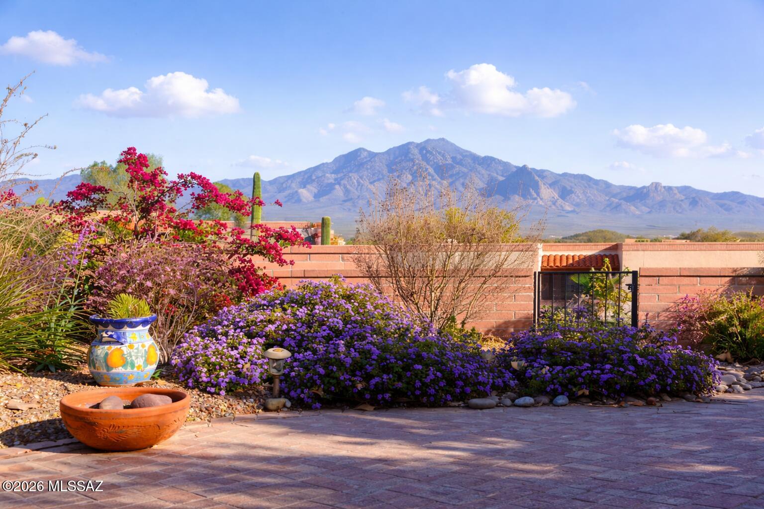 Located in the desirable 55+ community of Canoa Seca Estates II, this 2,050 sq ft Miramar model offers 2 BD, 2 BA + den in a quiet, private setting. Gorgeous, sweeping, mountain views create a beautiful daily backdrop for quiet sunsets and gatherings alike. Designed for easy indoor-outdoor living, the home features a wraparound covered patio surrounded by mature landscaping that enhances the serene private oasis. Inside, all-tile flooring & neutral palette provide a bright, cohesive feel, while a traditional beehive fireplace built in mesquite shelving adds warmth & Southwest charm. Guest parking is steps away, with nearby GVR centers rounds out this perfect location. Newer HVAC