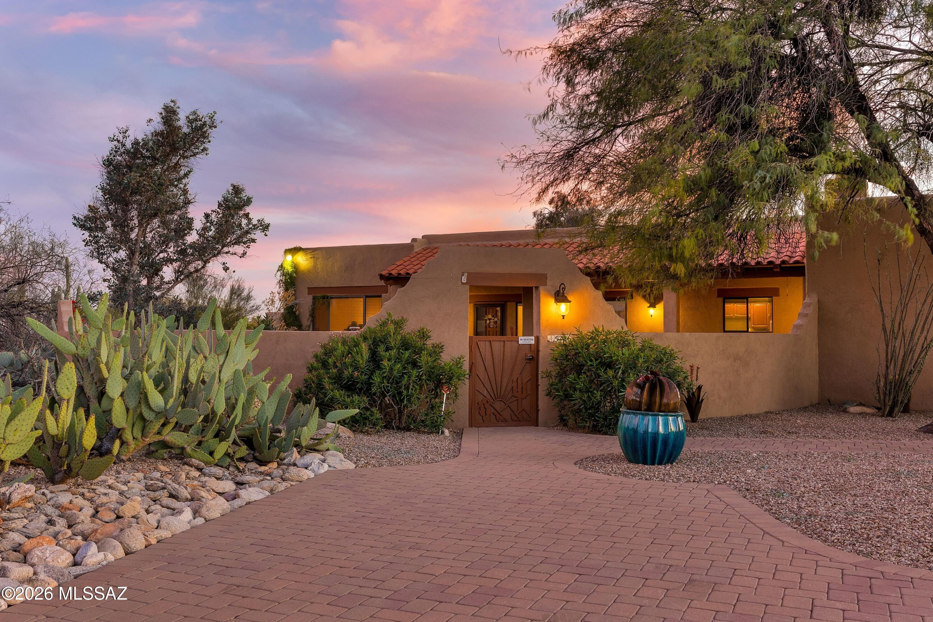 This exquisite Southwestern-style residence captures the perfect balance of privacy, sweeping desert vistas, and breathtaking sunset views, tucked deep within the highly sought-after Shadow Hills community, known for its wide, walkable streets and welcoming neighborhood charm. Set on a sprawling .70-acre homesite with mature landscaping, the homes is set deep on the lot. An expansive courtyard and covered porch create inviting spaces for quiet mornings framed by Catalina Foothills Mountain views or relaxed evenings under Tucson's glowing skies. Inside, high ceilings, a gracious foyer, and generously proportioned living spaces establish an open, airy ambiance. Windows frame the surrounding Sonoran Desert, filling the interiors with soft natural light. The beautifully updated kitchen showcases newer cabinetry, granite countertops, a tiled backsplash, stainless steel appliances, and a breakfast bar for casual dining. Open to the spacious family room, this thoughtfully designed layout supports both effortless entertaining and comfortable everyday living, anchored by a charming corner gas fireplace.
Designed with privacy in mind, the ideal split-bedroom floor plan offers spacious accommodations for both family and guests. The expansive owner's suite serves as a retreat, complete with its own cozy fireplace, direct patio access, a generous walk-in closet, and a spa-inspired bath featuring a garden tub and separate shower.
Outdoors, the oversized backyard is perfectly suited for Tucson's year-round lifestyle. A recently re-plastered sparkling pool and an expansive covered patio provide plenty of space for dining, entertaining, or simply relaxing beneath vibrant desert skies and the spectacular sunsets Tucson is known for. Mature, manicured desert landscaping enhances the property, while attractive pavers line the driveway and guest parking areas add both elegance and functionality.
Located within the highly regarded Catalina Foothills School District and just minutes from premier dining, shopping, and convenient access to downtown Tucson, this exceptional property offers the rare opportunity to enjoy space, privacy, and refined desert living in one of the area's most desirable communities.