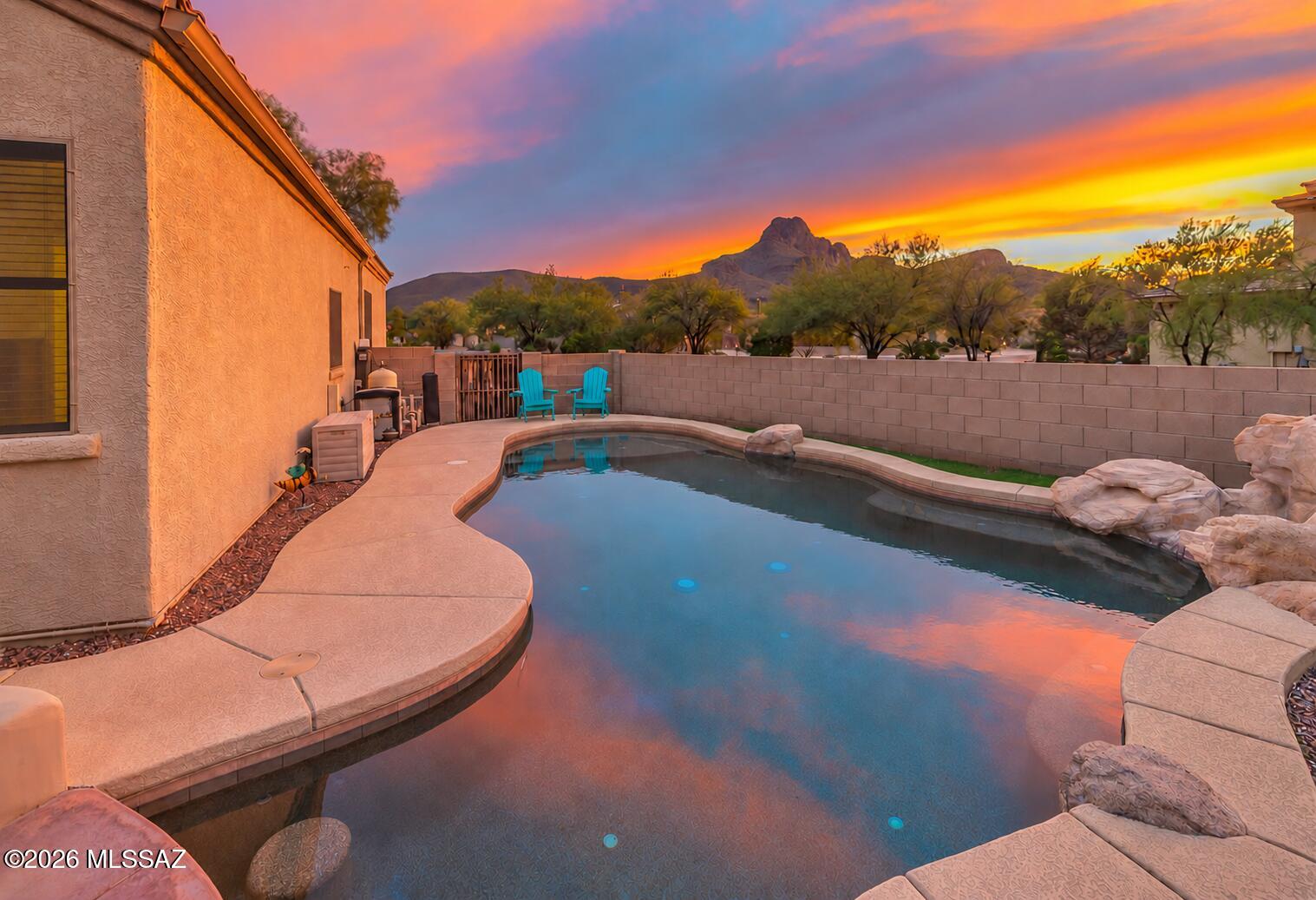 Imagine ending each day with mountain and sunset views from your own private desert retreat. Situated on a spacious quarter-acre lot in Continental Reserve, this inviting single-story home offers 4 bedrooms, 2 bathrooms, and 2,260 square feet with a split-bedroom floor plan and open living spaces.
The backyard is made for gathering and relaxing, featuring a PebbleTec pool with a sun shelf and swim-up seating, an outdoor kitchen, a gas fire pit, artificial turf, and plenty of room to entertain. Inside, tall ceilings and a comfortable, open layout create an easy flow from the kitchen to the dining and family rooms. With a large extended driveway, built-in garage storage, and convenient access to shopping, dining, and recreation, this home offers the space, privacy, and Arizona lifestyle you have been looking for.