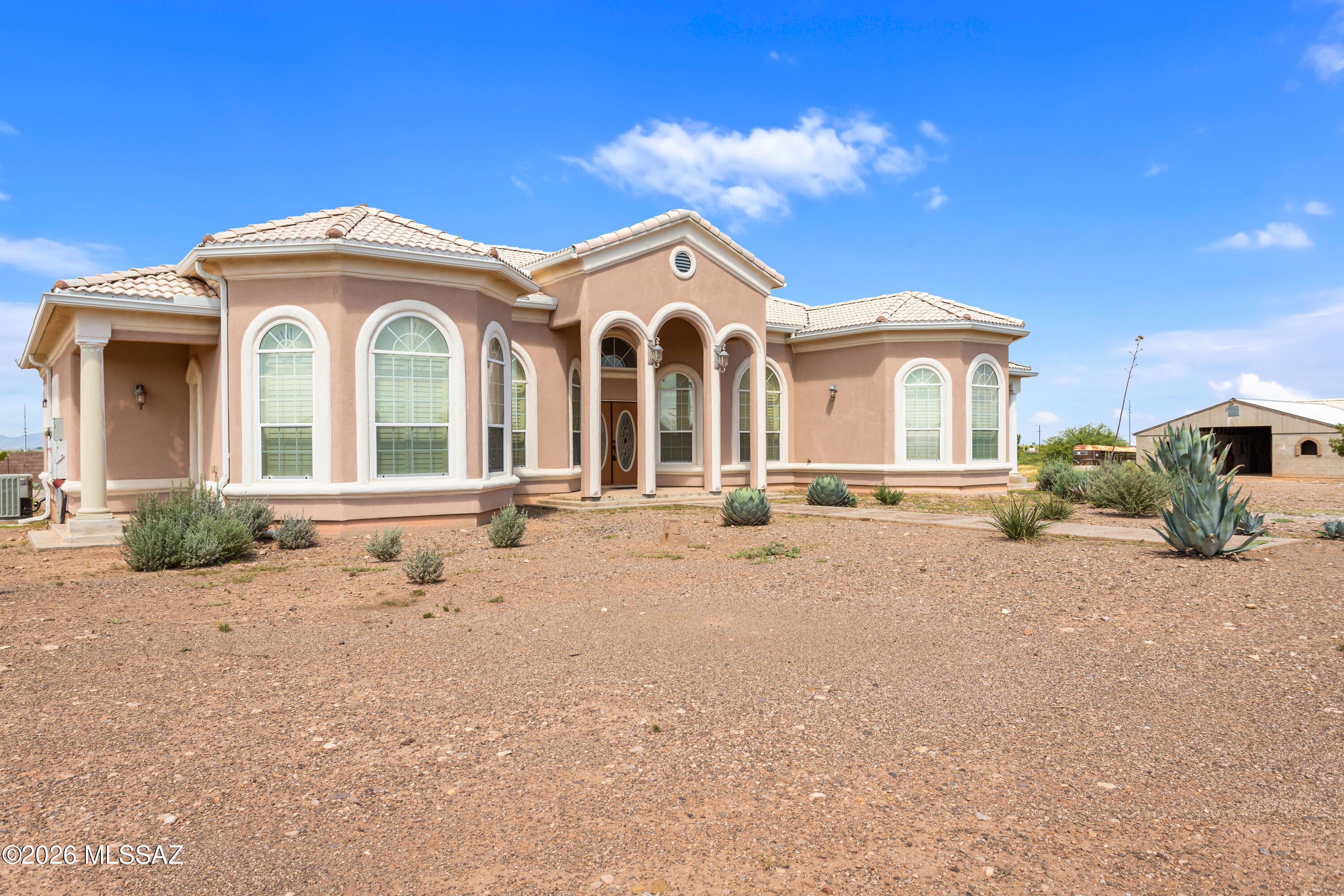 Horse property done right! This impressive equestrian property pairs a spacious 2,736 sq. ft. home with approximately 10 acres and a horse setup that is hard to find. The centerpiece of the property is the substantial 11-stall horse barn, complete with a wide center aisle, power and water, and plenty of additional space for tack, feed and hay storage. An unfinished portion of the barn also offers exciting possibilities--the previous owner had envisioned converting the space into a mother-in-law or guest suite, giving the next owner the opportunity to finish the vision or utilize it for additional equestrian needs, a workshop or storage.
The home itself offers plenty of room to spread out with 5 bedrooms, 2.5 bathrooms, a living room, separate family room and formal dining area. The fifth bedroom can easily serve as a home office or craft room. Tile flooring throughout makes the home both attractive and practical for country living.

The spacious kitchen features abundant cabinetry, granite countertops, a large center island, farmhouse-style sink and stainless appliances. Architectural details throughout the home include soaring ceilings, arched doorways and windows, plantation shutters and an inviting primary suite with a fireplace.

Outside, enjoy the wide-open Southern Arizona setting from the covered patio and ramada, with plenty of acreage for horses, trailers, equipment and all the extras that come with the rural lifestyle. A three-car garage provides even more storage and workspace.

With an established 11-stall barn, approximately 10 acres, a spacious home and room to make the property your own, this is an opportunity for the horse enthusiast looking for more than just a house--it's a place to bring the horses home.

Seller is in the process of splitting approximately 10 acres to convey with the home. Seller may consider selling more or even less acreage with the sale.
