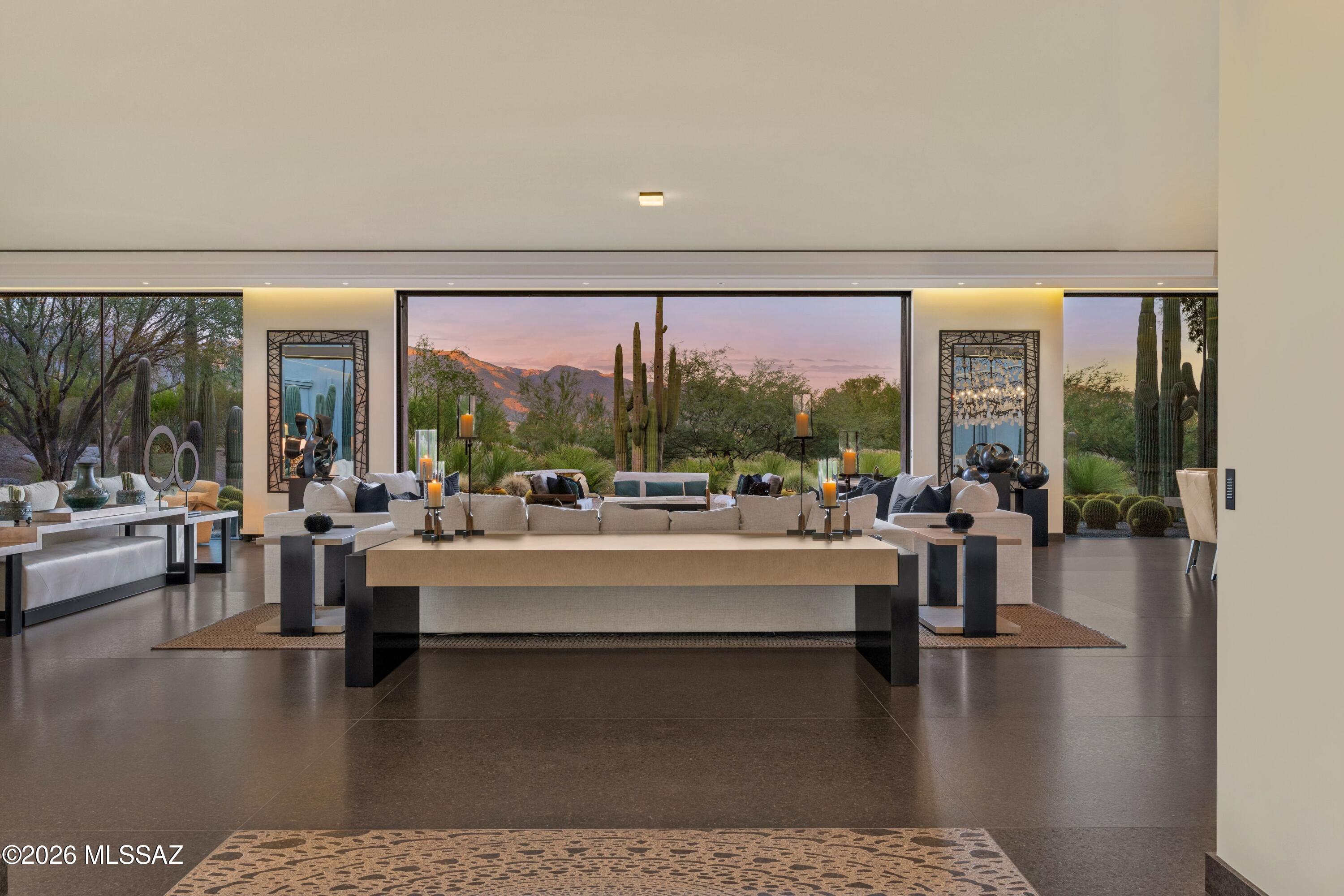 Step into The Desert Retreat, an exquisite turnkey estate tucked away within the gates of Canyon Ranch in Tucson, AZ. This architectural masterpiece showcases an international collaboration between G & M Design of Monaco and Bart Reines in Miami. Brilliant minds and expert skills created a truly one-of-a-kind experience blending quiet sophistication and elegance with the artful desert landscape. Meticulous attention to detail is shown throughout the residence, grounds and private spa. Perfectly positioned on the 1.4-acre lot to maximize both views and privacy, the setting is compelling. Contemporary lines with vertical and horizontal layers playfully interact with the organic shapes of the surrounding cacti. Built to commercial standards with masonry construction, the property will stand the test of time. Intentionally, there is no clear path to the main entry. Instead, a stroll through nature leads to a stately entrance, creating contrast and interest.

Stepping inside evokes a feeling of awe, yet there is an intrinsic calmness. Every design element was purposefully selected to create a holistic and harmonious experience. Italian slab granite underfoot grounds the space, seamlessly connecting to the stone cladding on doors, cabinetry and trim work. Thoughtfully placed throughout the home, a signature piece of custom artwork has been laser etched into the floors. Walls of oversized glass provide visual pathways to the landscape, while also creating natural separation between rooms. Every functional element is hidden from the eye, including venting, speakers, window coverings, power and lighting controls.

Designed with 4 suites, each guest has an entirely private sanctuary. Appointed with custom furnishings, seagrass flooring, generous closets and spa-like baths with views of the garden or mountains. Each suite may be independently controlled for light, temperature and sound. 

Both grand in scale and surroundings, the salon showcases an interplay of neutral tones with layers of greenery outside. The indoors and outdoors unite in this magnificent space with floor to ceiling glass and cascading doors that disappear into the surrounding walls. While large groups are easily accommodated here, there are opportunities to create intimate settings as well.

Stepping outdoors, a world of tranquility is found. The grounds are blanketed in perfectly placed specimens of cacti, yucca and grasses that create a botanical garden-like setting. Sitting above Sabino Creek with exposure to the Rincon, Catalina and Santa Rita Mountains provides a unique environment both in terms of natural beauty and habitat. Low lying giant Cottonwood trees and Mesquite bosques reside in contrast with the elevated saguaro. Quite moments can be discovered throughout, creating opportunities for meditation, birdwatching or reflection.

A soul soothing escape is found at the property's private pool and spa. Nestled into the topography to feel cocooned while maintaining open sightlines to the mountains. Pebbles sourced from riverbeds and beaches of Southeast Asia blanket the pool and deck, providing both a soothing aesthetic and reflexology benefit. Steps away, the wellness journey continues. A stand-alone spa building has been built to the standards of a 5-star resort and includes an outdoor shower, steam room and massage room. Each space was meticulously crafted to envelop the senses.

Steps away, sit the amenities and wellness services of the world class Canyon Ranch Resort. Owners and their guests enjoy access to the incredible facilities and an array of daily activities, that include movement, mindfulness and well-being. Each day can be a unique journey. This is only the beginning, as the resort's experts include top professionals in medicine, nutrition, performance, longevity and spirituality.