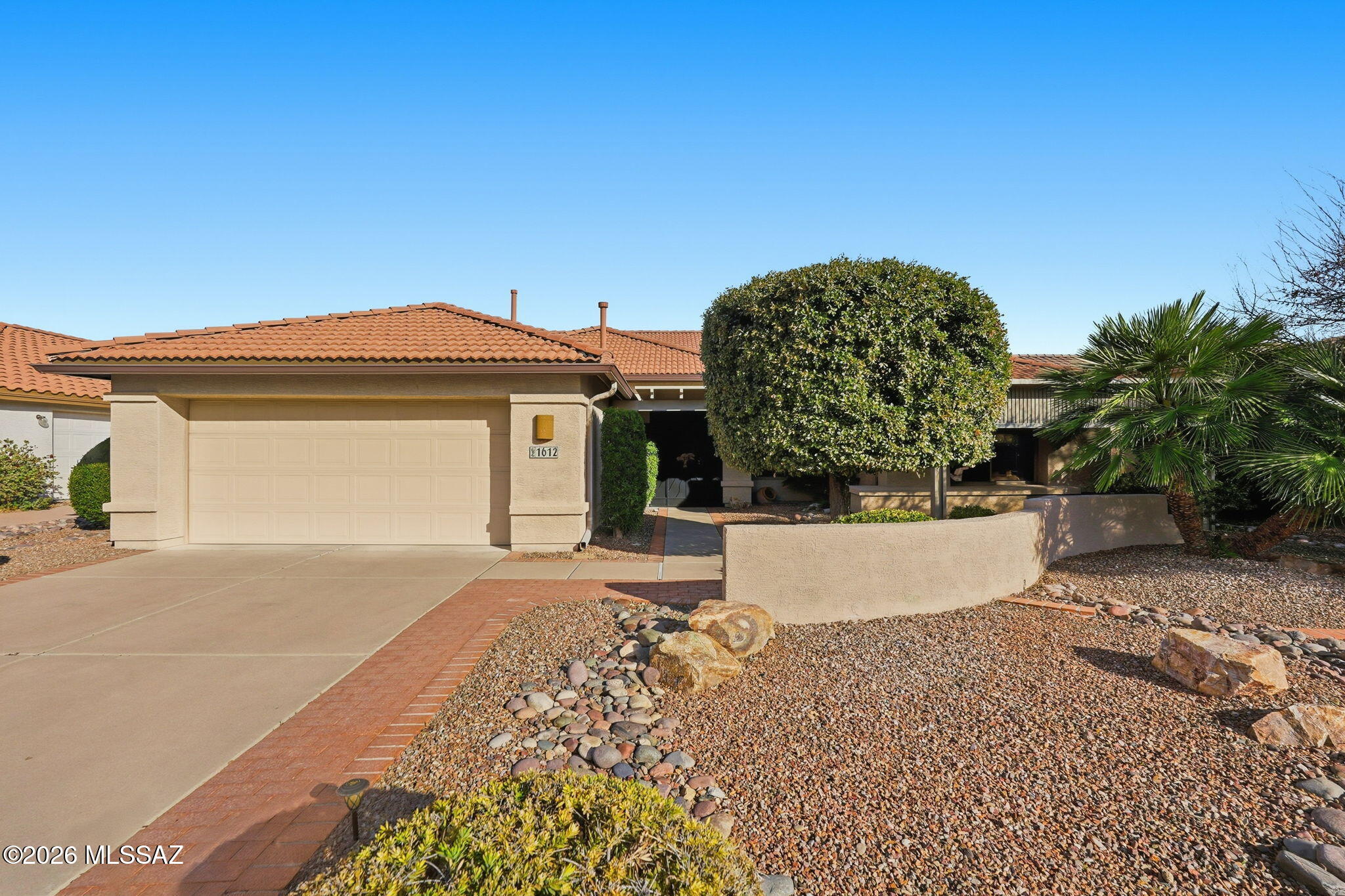 The big-ticket updates are done--now it's time to enjoy the Quail Creek lifestyle! Beautifully maintained and generously sized, this popular Montana floor plan combines space, comfort, and peace of mind with a long list of recent improvements already completed for you. Perfectly positioned on a cul-de-sac in the resort community, this is a home move in ready. Major updates include a new roof installed June 2023 with double underlayment and remaining warranty, two HVAC systems replaced November 2022 with 10-year warranties, and a 50-gallon water heater installed October 2024. Even the irrigation system received special attention, upgraded around 2019 to durable PVC piping rather than standard tubing and thoroughly inspected and renewed again in March 2025. Mature landscaping and lush vegetation create beautiful curb appeal as you arrive. The two-car garage provides built-in cabinetry for extra storage before you step inside to a light-filled interior with soaring vaulted ceilings and expansive windows. The spacious living room offers plenty of flexibility for arranging furnishings and creating gathering spaces that fit your lifestyle. Two dining areas give you options for casual breakfasts or dinner with friends, both conveniently located near the generously sized kitchen. Here, abundant cabinetry, expansive countertops, and an oversized pantry closet provide exceptional storage and workspace. Just off the kitchen, the laundry room and direct garage access make bringing in groceries a breeze. A separate den/office adds even more versatility for working from home, hobbies, or additional guest space with the convenient Murphy Bed. The spacious primary suite is filled with natural light and offers an ensuite bath with dual cultured-marble vanities, walk-in shower, and a custom closet organization system. The guest bedroom is equally impressive with a beautifully crafted built-in wood bed, surrounding cabinetry, and integrated desk, creating a multifunctional space ready for overnight visitors and everyday use. Then step outside and discover your own private Arizona retreat. The covered patio has been extended with an attractive aluminum wood-look pergola, providing additional shade over beautiful brick pavers. Mature trees and thoughtfully placed plantings create a peaceful oasis, while decorative rock landscaping keeps upkeep to a minimum. Meticulously maintained, thoughtfully updated, and tucked into a desirable cul-de-sac, this Montana Floor Plan offers the space you want, the major improvements you'll appreciate, and the resort lifestyle that makes Quail Creek such a special place to call home.