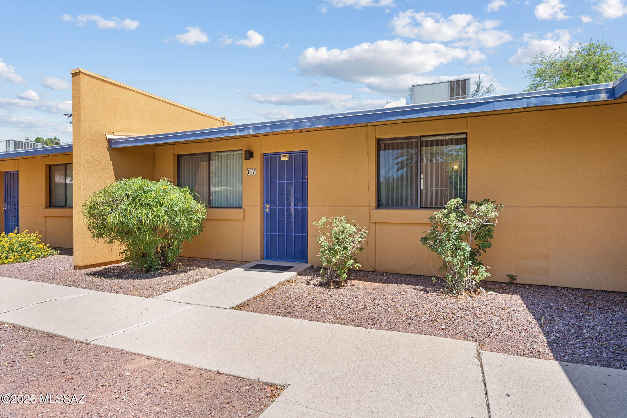 Welcome to this beautifully updated and move-in-ready 2-bedroom, 1-bathroom townhome-style condo, blending modern comfort with inviting Tucson charm. From the moment you arrive, the vibrant exterior accents and neat, low-maintenance landscaping create a warm welcome. Inside, you are greeted by a comfortable living area featuring rich, wood-look flooring, updated neutral paint, and an abundance of natural light pouring through the large front window.

A wide doorway transitions you into the separate, pristine eat-in kitchen, boasting chic gray cabinetry, an eye-catching deep blue  backsplash, modern white gas range, and a sleek stainless steel refrigerator. Sliding glass doors lead directly from the dining space to your private backyard oasis--a true highlight of this property. The seller has meticulously transformed this outdoor area into a peaceful, gravel-scaped retreat perfect for morning coffee or evening relaxation, complete with a cozy patio space, mature desert plantings, and secure fencing.

Both bedrooms offer comfortable dimensions and plenty of closet space, while the beautifully updated bathroom features modern vanity fixtures, crisp white tiling, and dedicated built-in storage. Conveniently located near local dining, shopping, and transit, this charming property is ready for its next owner to just move in and enjoy. Schedule your tour today!