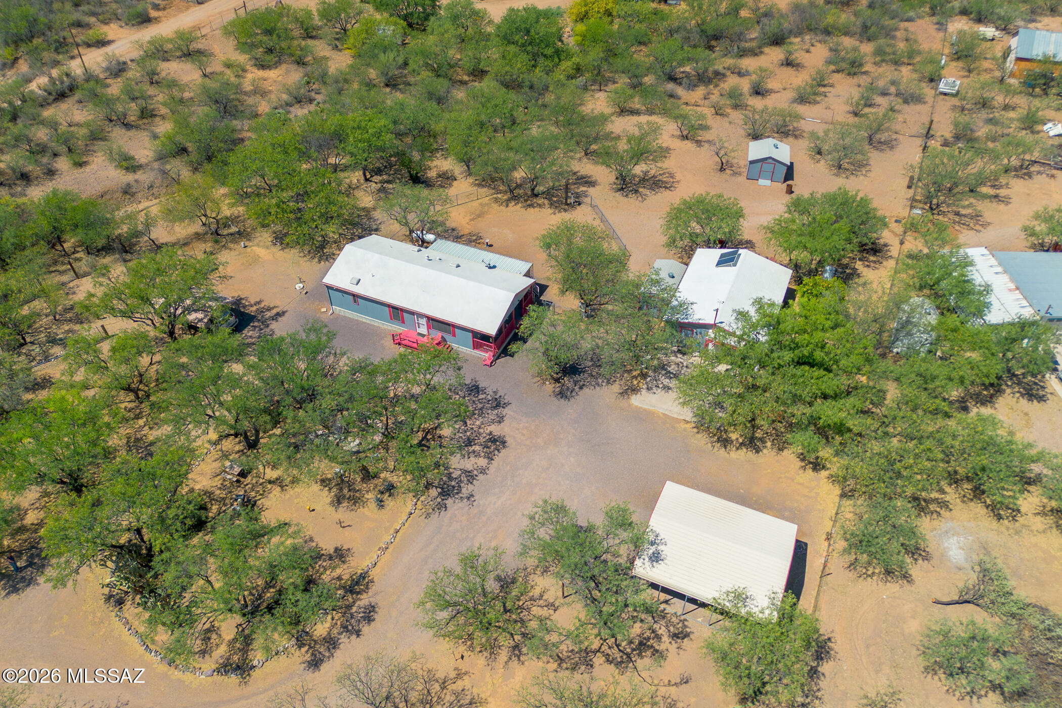 This special, one-of-a-kind property offers a quiet, country lifestyle with excellent amenities for all members of the family. Parents will appreciate the safety and security of a gated, completely fenced 2.5 acres and chain link fencing in the backyard. The large, shaded yard is a wonderful play area for children and pets. And, for 4H kids it is zoned for horses and livestock. From the manicured landscaping step onto a wrap-around deck to enter a clean, well-maintained home featuring a great room, vaulted ceiling and abundant natural light. A gas range and ample counter space, including a breakfast bar, simplify meal preparation. Add fresh citrus from the garden to enhance your recipe. For dads the 32x50 garage/shop becomes a welcomed retreat after a long workday and comes fully stocked with valuable equipment - tools. compressor, generator, chainsaw, etc. This tandem garage, 10x20 and 24x24 carports and 2 storage sheds are essential for collectors. A small water company services this property at a monthly cost of $50. There is also RV parking with full hook-ups.