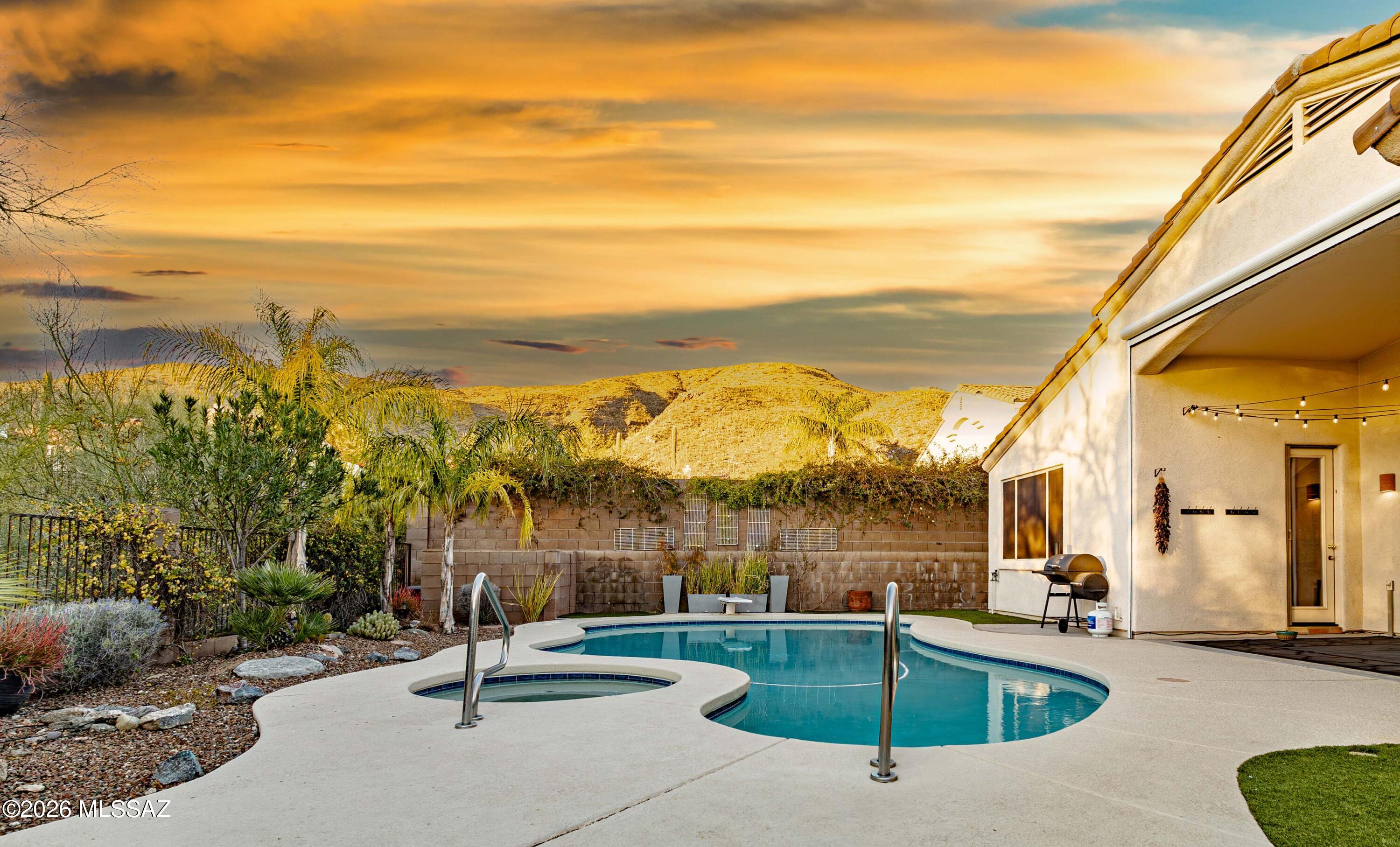 Welcome to your private desert retreat in the gated community of Sabino Springs!  This beautifully updated, single-story home offers 4 bedrooms, 2.5 bathrooms, and 2,323 square feet of thoughtfully designed living space with an open, split-bedroom floor plan. From the moment you arrive, you'll appreciate the beautiful desert landscaping, year-round blooming flora, and exceptional mountain views. The heart of the home is the renovated kitchen, featuring 42-inch alder cabinetry, stainless steel appliances, granite countertops, a center island, and a generous breakfast bar--perfect for everyday living and entertaining. The spacious living room offers a cozy gas fireplace and large sliding glass doors that fill the space with natural light and provide a seamless connection to the backyard. Your backyard is truly an oasis, complete with a heated saltwater pool and spa featuring a newer heater and filter system. Enjoy breathtaking views of the Santa Catalina Mountains from your private outdoor retreat, surrounded by lush turf, desert plantings, newer drip irrigation, and the added privacy of no homes directly behind the property. The spacious primary suite boasts an oversized bathroom with dual vanities, a soaking tub, separate shower, private toilet room, and an enormous walk-in closet. Plantation shutters throughout add timeless style and privacy. Numerous recent updates provide peace of mind, including a newer HVAC system (2024), water heater (2024), and roof (2023), plus brand-new interior paint and carpet throughout. The massive 3-car garage offers built-in cabinetry and a water softener. All appliances convey, including the refrigerator, washer, and dryer. Tucked away in the desirable gated Sabino Springs community, residents enjoy access to a pool, spa, exercise facility, and sidewalks throughout, while the public golf course and restaurant are conveniently within walking distance. With its exceptional outdoor living, mountain views, extensive updates, and ideal community amenities, this home offers the best of comfortable desert living in a truly special setting.