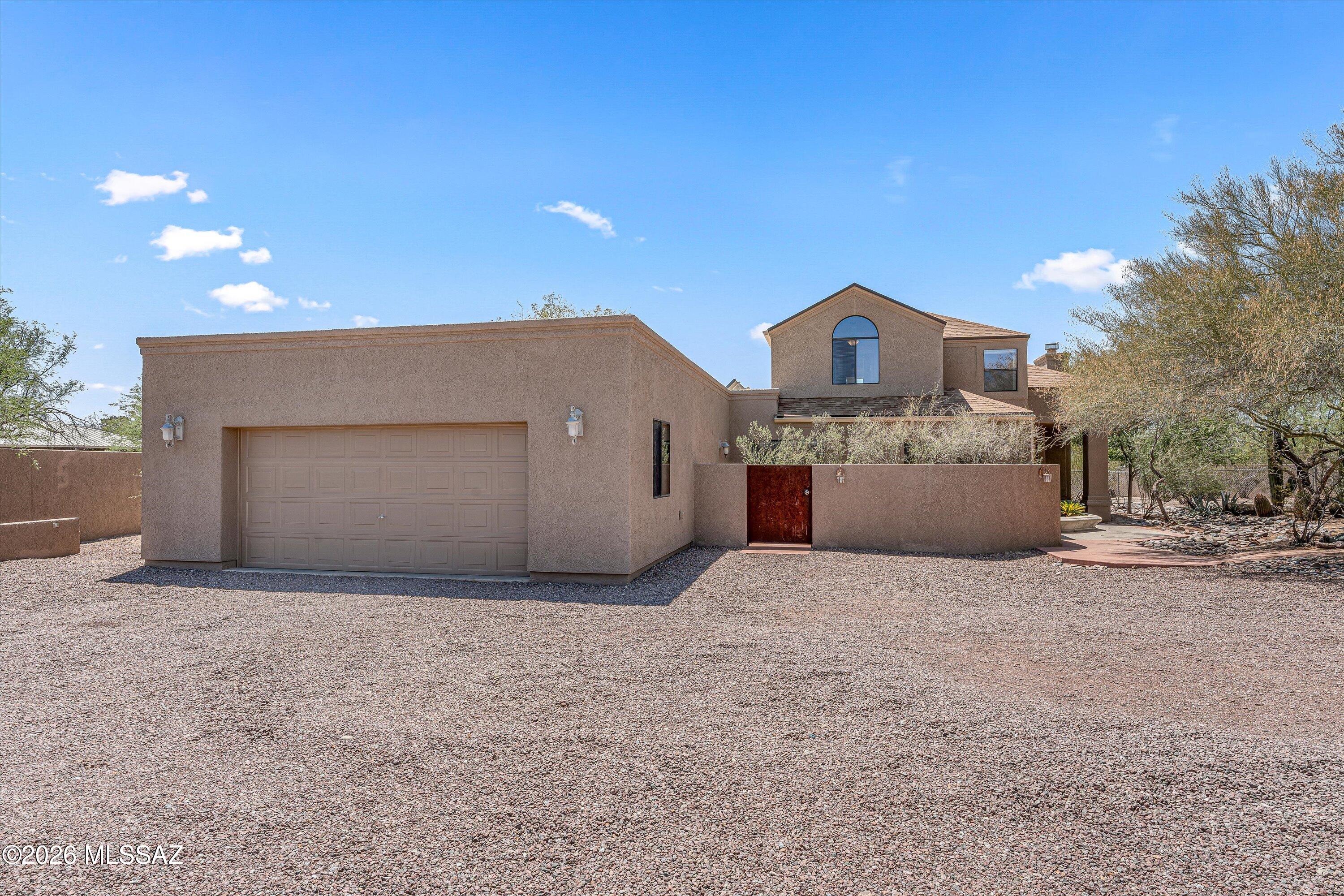 If you seek privacy and quality, this custom home on a fully walled acre with private gate and separately gated RV parking is for you! Step into a grand space for living and formal dining that shares a wall of windows with the family room/kitchen and access to the tiled covered patio with mountain and desert views. The updated and well appointed kitchen with breakfast bar has modern stainless steel appliances, granite counter tops, double ovens and ample counter and cabinet space for the most select of chefs. The primary bedroom is on the main level and features a large bedroom with sitting area, private patio, gorgeous ensuite bath and bespoke walk-in closet. Also on the first level is a powder room, spacious laundry room with counter space, sink, and storage, an oversized garage with built-in cabinets, and a separately cooled space that could be used as an office, workshop, darkroom, etc. Upstairs features an office loft, an ensuite, and two additional bedrooms and bath. Zoned A/C for each level of the home, solar hot water heater, Hunter-Douglas window shades, and LED lighting throughout provide energy efficiency and green living. All of this on Tucson's coveted Northeast side, convenient for shopping, dining, and quick trips to Mt Lemmon.