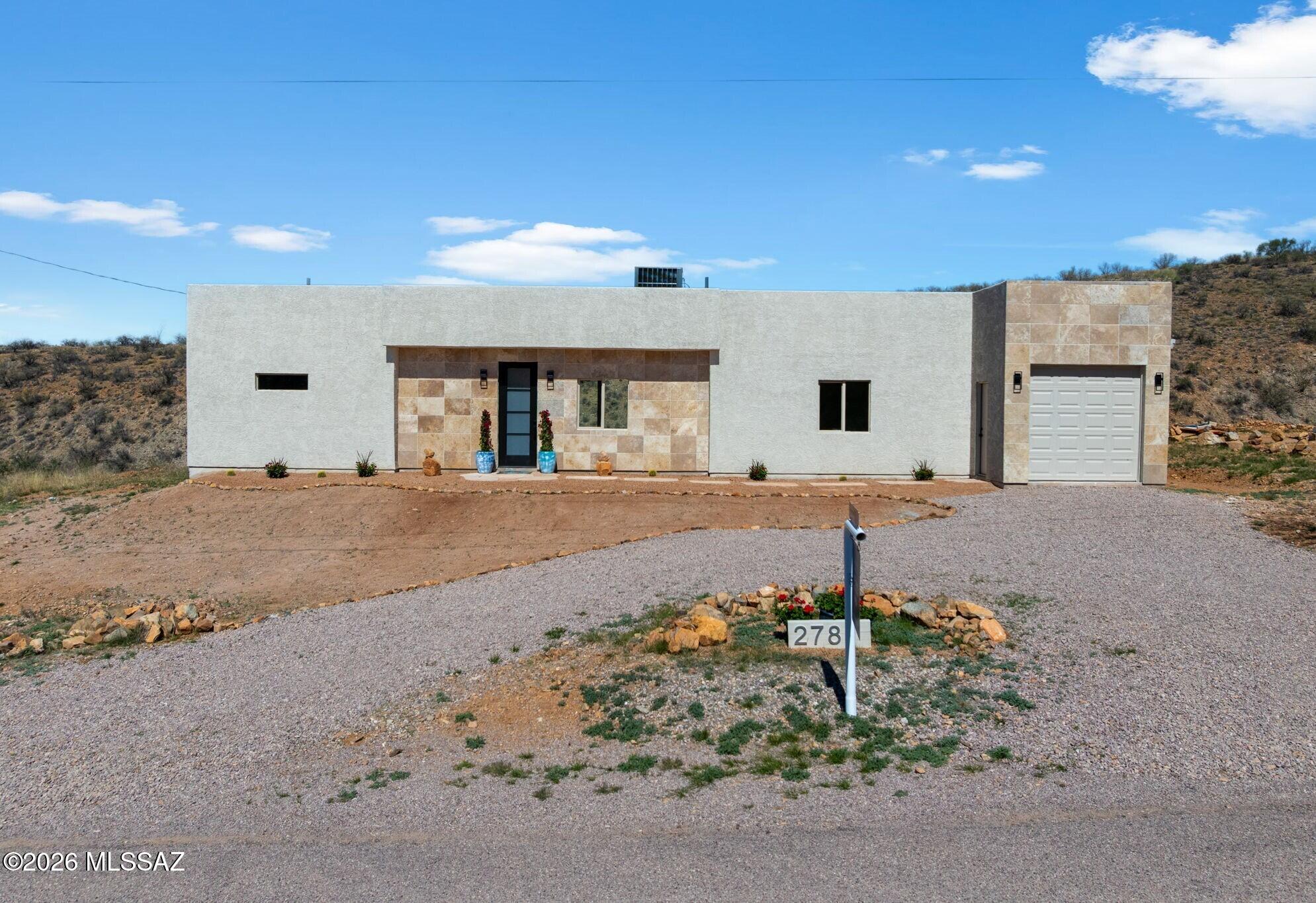 Just completed and move-in ready!!  This stunning new construction home in Rio Rico, AZ offers modern design, thoughtful finishes, and breathtaking mountain views. From the moment you arrive, the home makes a statement with a striking front elevation featuring custom tile accents, creating strong curb appeal and a distinctive modern Southwestern aesthetic.
Inside, the open-concept layout is filled with natural light and anchored by 24x12 porcelain tile throughout, delivering a sleek, cohesive look that's both durable and elegant. 8-foot interior doors enhance the sense of space and elevate the architectural feel throughout the home. The chef-inspired kitchen is the centerpiece of the home, showcasing quartz countertops, 48-inch upper cabinets for exceptional storage, and a huge kitchen island perfect for entertaining and everyday living. A strategically placed chef's sink enhances functionality while keeping the space open and connectedperfect for hosting, meal prep, and gathering while maintaining an open flow.
The primary suite offers a private retreat with a spa-like bathroom featuring a dual vanity, modern finishes, and thoughtful design. Spacious secondary bedrooms provide flexibility for guests, office space, or hobbies, while additional bathroom continues the clean, contemporary aesthetic.  
Large windows frame sweeping desert scenery, city lights, and mountain views, seamlessly connecting indoor living with the surrounding landscape.  With modern construction, elevated finishes, and standout curb appeal, this home is a rare opportunity to own a brand-new residence with custom design elements and panoramic views.
350 sq. ft. oversized 1 car garage (31.5' x 11').  Plenty of room for quads, side-by-side, all the toys.  Could fit 2 compact cars.  An amazing property priced to sell!!!