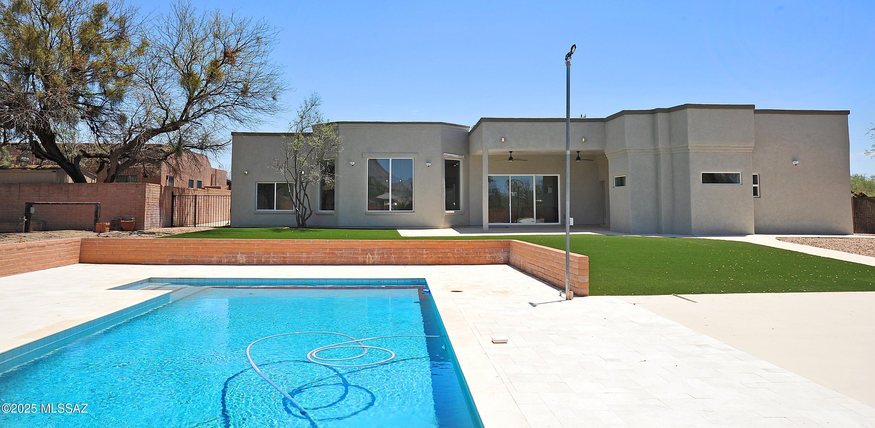 Tucson's Best remodel. Located in desirable and popular Richland Heights West neighborhood. This amazing lot is just under 1 acre of land and has amazing Catalina mountain views. The property is fully fenced and gated. This split floor plan consists of 4 oversized bedrooms with full on suite bathrooms, a large office/Den with double glass doors, and 5 full bathrooms. New kitchen with solid wood cabinets, soft close doors and drawers, dove tail drawers, granite countertops, undermount sink, an oversized island with room for seating up to 8 and pendant lighting. New Stainless steel appliances to include: microwave drawer, 48'' dual fuel professional Double range, dishwasher,  72''  Refrigerator- (full size freezer and fridge with ice and water dispenser). 5 full bathrooms with beautifully tiled shower surrounds, glass door, solid wood vanities, lighted mirrors, undermount sinks, modern lighting. Super oversized laundry room with an abundance of cabinetry, a separate living room with wood burning fireplace. Additional features include: alarm system from Accura on all windows and doors with motion detectors, new stucco, new roof, new windows and doors, new electrical wiring, Replaced interior plumbing lines, iconic dirt roads with 2 sided access, one entrance is fully paved and gated, new porcelain tile throughout- No Carpet, 2 car garage with A 50amp EV Charger, 2 new 50 gallon gas water heaters, 3 HVAC units with all new ductwork, smart video floodlights, 72" iron and glass front door, expanded brick paver driveway, lighted refinished sport court for pickleball, basketball, tennis and more. Refinished oversized pebble tech pool with pool vac and a platinum ice marble pool deck. Gorgeous gazebo in back yard with electrical hookup, new turf, solid masonry storage shed/Workshop, plenty of room for RV, guest house, detached garage, horses, animals. NO HOA. Close to UofA, downtown, shopping, hospitals, resorts, hiking, golf and restaurants.  This is an incredible home for the price. Plenty of room to add a casita, or an RV garage