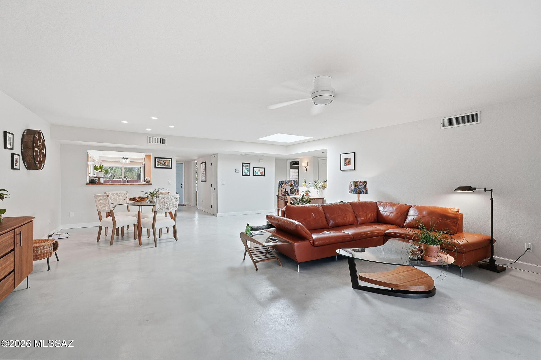 Step into a home where natural light shapes the experience from the moment you enter. The foyer opens directly into the main living area and dining space, where skylights add a changing glow throughout the day. Polished concrete over lay polished flooring, updated kitchen and bathrooms, stainless steel appliances, and a water softener bring thoughtful function to the space. The screened-in covered patio extends the living experience outdoors, framing unobstructed desert views and city lights. Located in Tierra Serena with access to a recreation center, pool, spa, and tennis courts, this home offers a setting that blends comfort with the surrounding landscape. There is a moment here when the light meets the view that no photograph can fully capture.