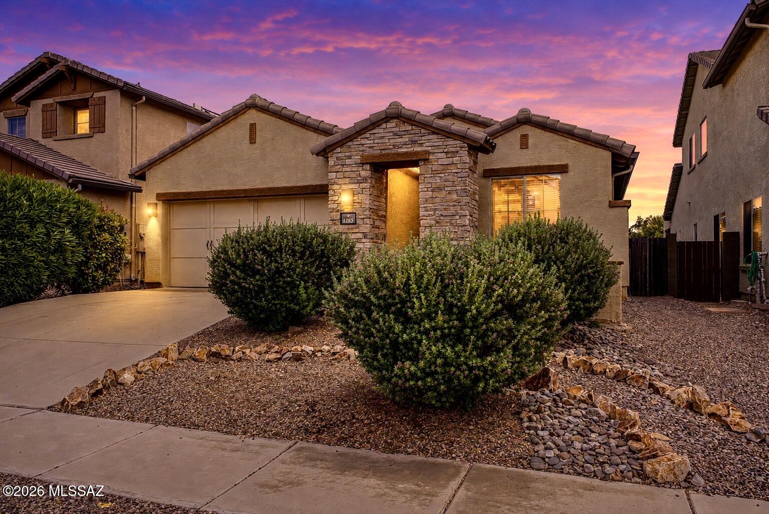 This move-in ready Oro Valley home offers the perfect blend of comfort, functionality, and low-maintenance desert living. Featuring a desirable split-bedroom floor plan with 3BR + den, the spacious single-level layout is designed for both everyday living and effortless entertaining. The expansive great room showcases oversized tile flooring, abundant natural light, and a cozy fireplace that creates a warm focal point for the living space. The open-concept kitchen features rich cabinetry, granite countertops, stainless appliances, a gas range, and a seamless connection to the dining and living areas. Privately situated, the primary suite offers a relaxing retreat with a bay window sitting area, soaking tub, separate shower, and walk-in closet. The additional bedrooms and flexible den space provide options for a home office, media room, playroom, or guest accommodations. Outside, enjoy an attractive low-maintenance backyard and desert landscaping designed for easy upkeep and Arizona evenings outdoors. Leased solar adds energy efficiency and long-term utility savings. Conveniently located near parks, shopping, dining, and highly regarded Oro Valley amenities, this home combines space, comfort, and value in one inviting package.