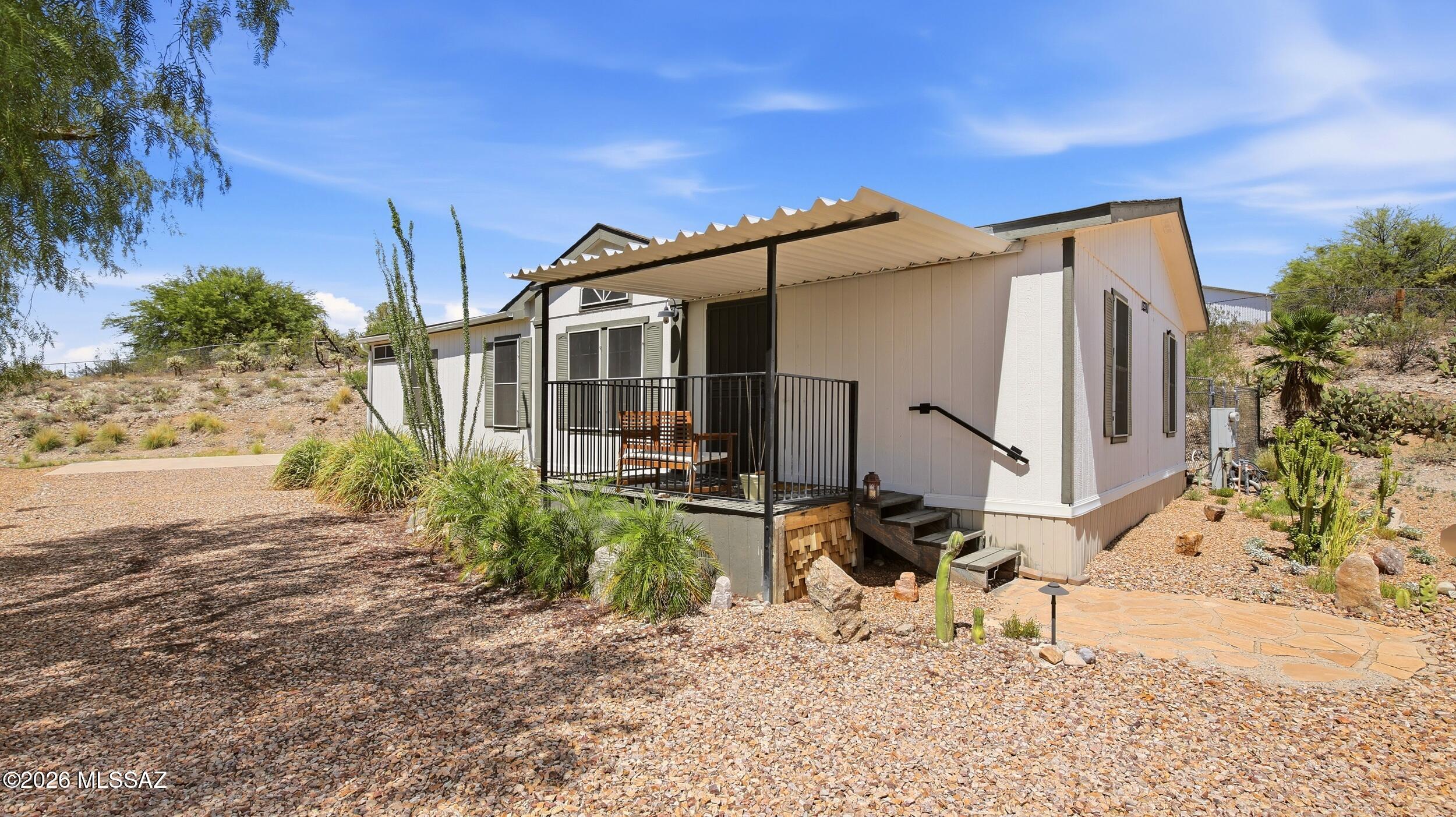 A Rare Acreage Opportunity with Privacy, Views & Room to Breathe! Tucked away on 1.5 acres with no HOA, this 3-bedroom, 2-bath home offers a peaceful desert setting with exceptional privacy. The 1,296 sq ft ranch-style residence features vaulted ceilings, dual-pane windows, updated flooring, spacious living areas, a comfortable primary suite, and a functional kitchen with full appliances. Step outside to expansive mountain and desert views, a covered deck, fenced yard, RV parking, and a detached 507 sq ft garage. Recent HVAC and propane system upgrades provide added value. A shared well and private septic system complete the property. Conveniently located within the Vail School District.