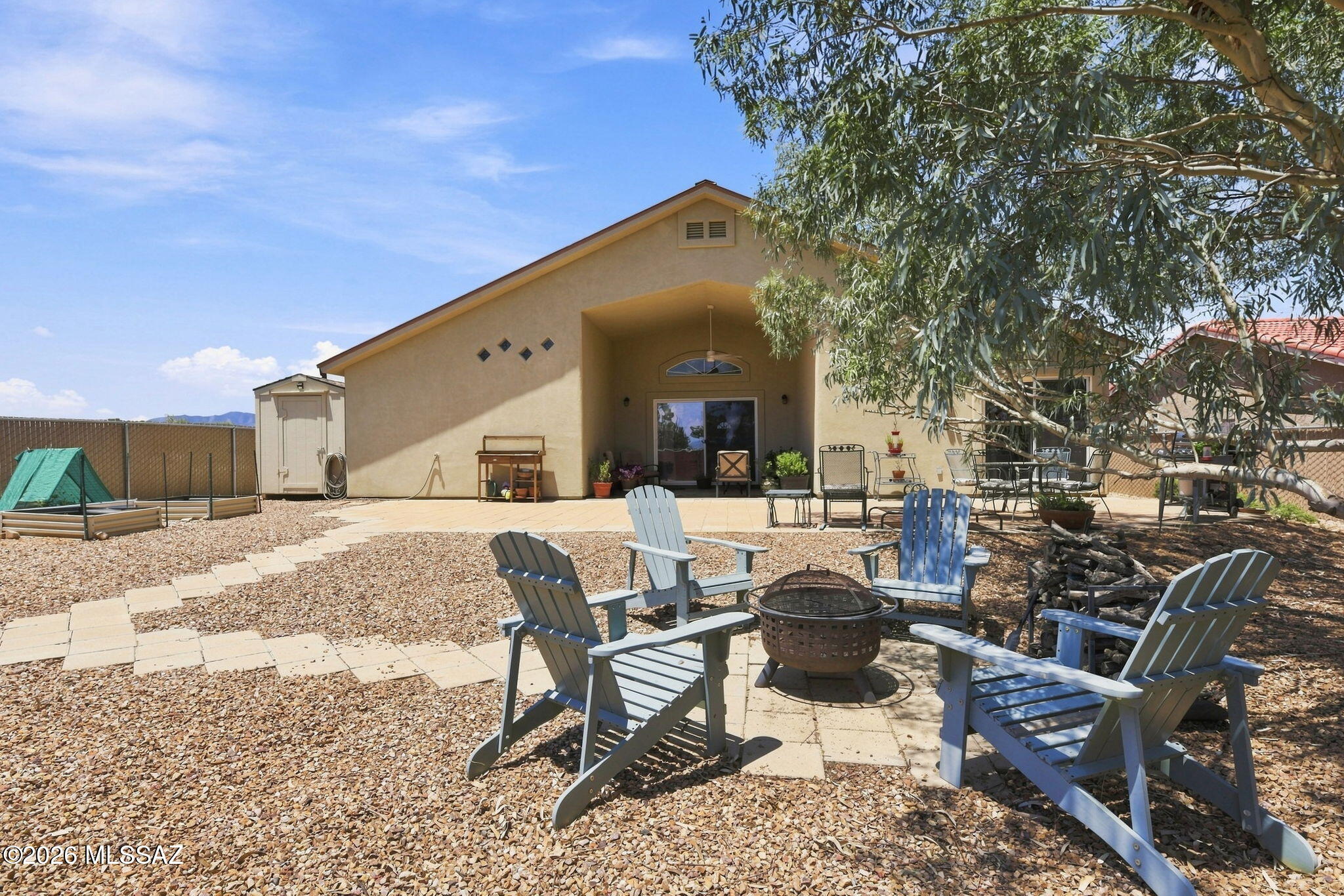 Perched with spectacular, unobstructed views of the historic Cochise Stronghold out front and peaceful mountain scenery from the fenced backyard, this custom home blends thoughtful upgrades with comfortable, open-concept living throughout. An expansive foyer with vaulted ceilings and premium ceramic tile with radiant floor heating welcomes you inside. The kitchen impresses with abundant storage, tiled countertops, and under-cabinet task lighting, flowing easily into the dining area and den/gathering room with a cozy gas fireplace. From the massive living room, sliding glass doors open to a spacious block patio, ideal for backyard BBQs and quiet morning sunrises. The primary suite is a true retreat, featuring an oversized walk-in closet and a bathroom with double vanities and a walk-in double shower. The second bedroom is equally spacious, with stronghold views and an extra-large closet with built-in shelving. A second bathroom nearby offers guests a stunning all-tile shower with a built-in relaxation bench. Energy-efficient windows, a durable metal roof, and low-maintenance desert landscaping complete this move-in ready home, while the front patio seating area sets the stage for unforgettable stronghold sunsets. This one won't last.
