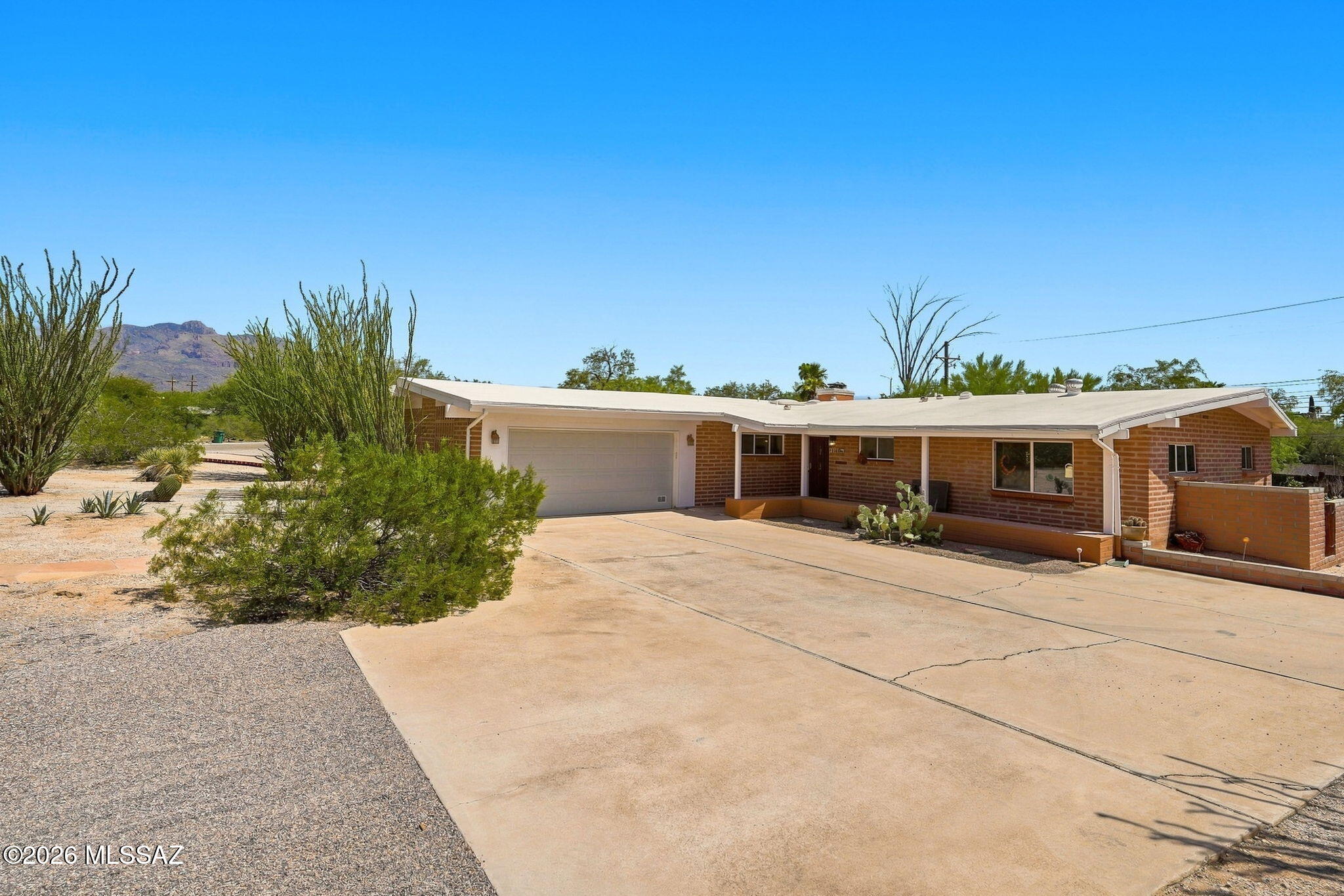 Mid century character and versatility... this distinctive Tucson home offers something increasingly hard to find. Vaulted ceilings with exposed beams and abundant natural light create an inviting interior. The kitchen features attractive cabinetry and granite countertops, while mostly newer windows and fresh paint give the home a refreshed feel. Outside, a large landscaped lot offers endless possibilities for outdoor living. A detached guest house with a full bathroom and private entrances offers flexibility as a guest retreat, office, studio, gym, or more. A circular driveway, two-car garage, subtle mountain views, and a convenient Casas Adobes location near shopping, dining, freeway access, and Downtown Tucson complete this unique property with space, character, and flexibility to enjoy!