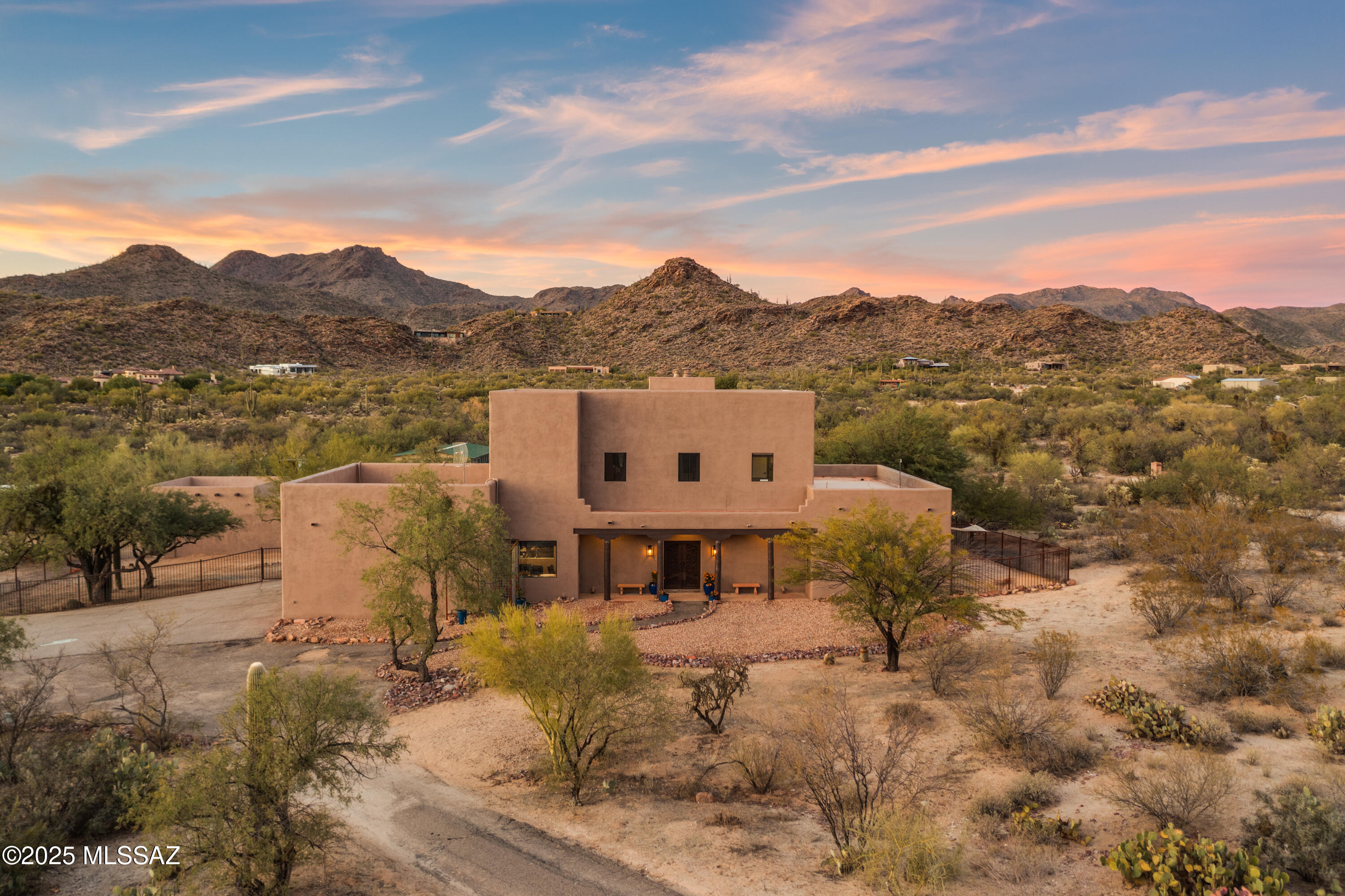 Are you searching for a quiet, peaceful life?  This home presents an AMAZING opportunity to experience lush desert, mountain views, and star gazing.  The beautifully updated home on 13.4 acres gives you the buffer of peace and quiet!  Set at the base of the Tortolita Mountains, this property has magnificent 360 views.  The updated, open concept home has a gorgeous kitchen with wide open views of the mountains from the living and dining area.  Two fireplaces, one in the living area and one in the primary bedroom add to the homey, comfy feeling of this home.  The flooring is tile throughout, and includes an office space and a large bonus room for hobbies, exercise or entertainment.  Enjoy sunset views from the balcony in the enormous primary suite with plenty of space for a home gym and an office.  This home was built with steel frames, has extra insulation and new exterior paint. The four car garage/workshop gives you room for all your hobbies.  The horse facilities include a mare motel, large turnout areas and additional pens.  It has No HOA and is in a wonderful, horse friendly neighborhood with a secluded feel, but keeps you conveniently close to northwest Tucson and Oro Valley stores and restaurants.  Come see it today!