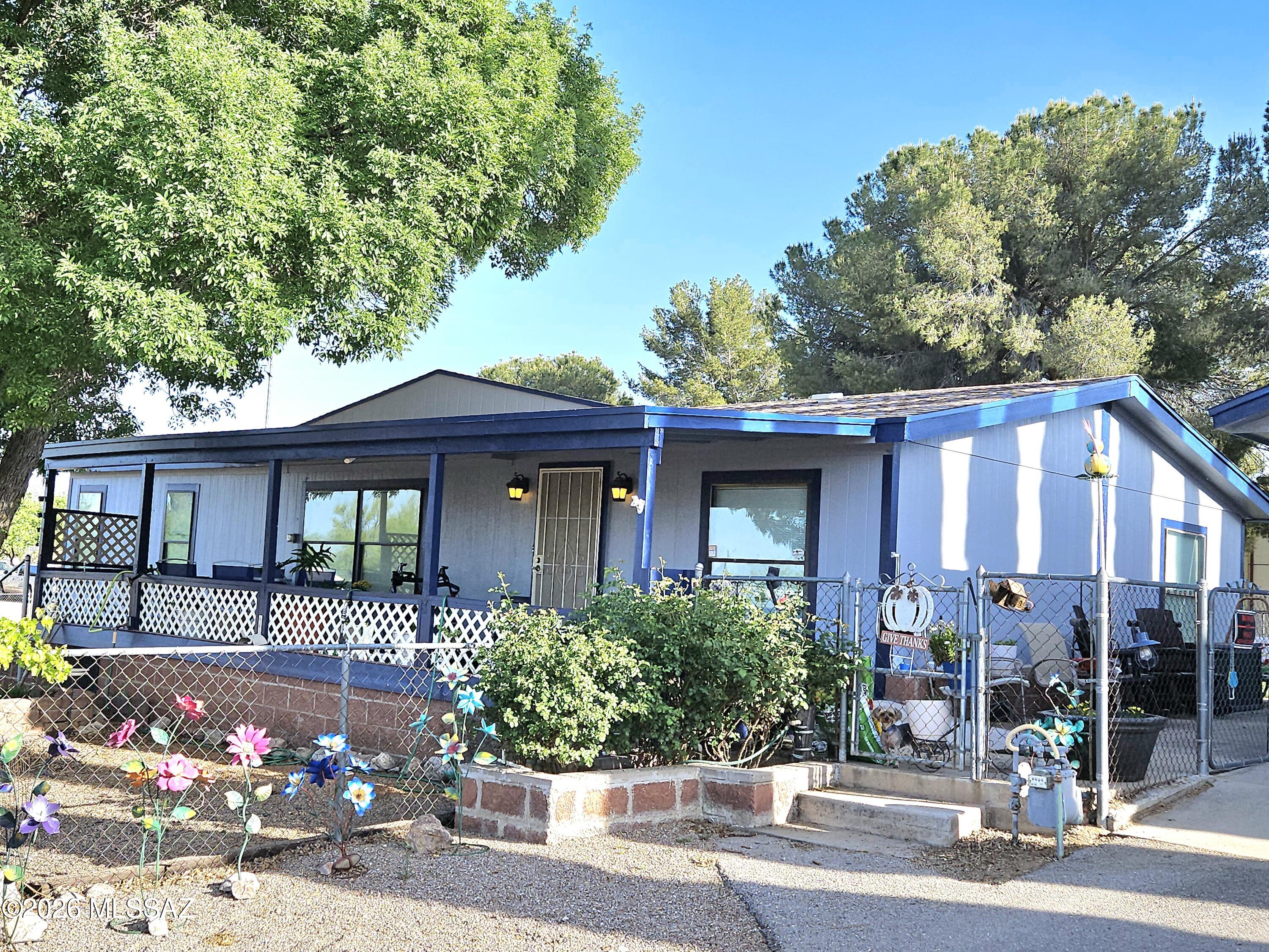 This property has so much to offer!   1991 1,568 sq. Ft. Home on a corner, double lot that is separately fenced w/chain link.  Mature shade trees & grass backyard creates your own desert oasis.  There is a new 10' x 15' shed w/a loft that offers lots of additional storage, hobby/craft room, art studio, or workshop.  There's an additional shed for even more storage. Two car detached garage w/work benches.  4 yr. Old roof. New laminate floors throughout w/a warranty guarantee. New water heater. Beautifully appointed kitchen w/pine cabinets that have soft close drawers & pull outs. Open, split bedroom floorplan. Ceiling fans throughout.  On a paved street w/easy access to I-10 for commuting to Tucson or Sierra Vista. Come see this one TODAY!!